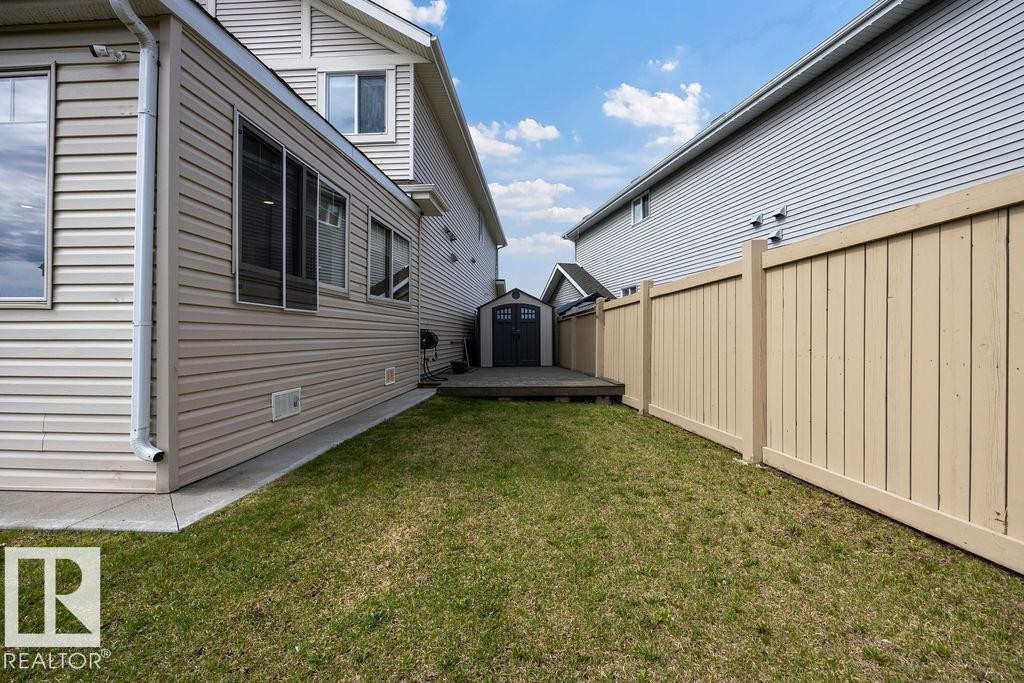 Manicured lawn with a privacy fence, wood deck, and detached storage shed - 13703 166 Avenue Nw, Edmonton, AB - Outdoor