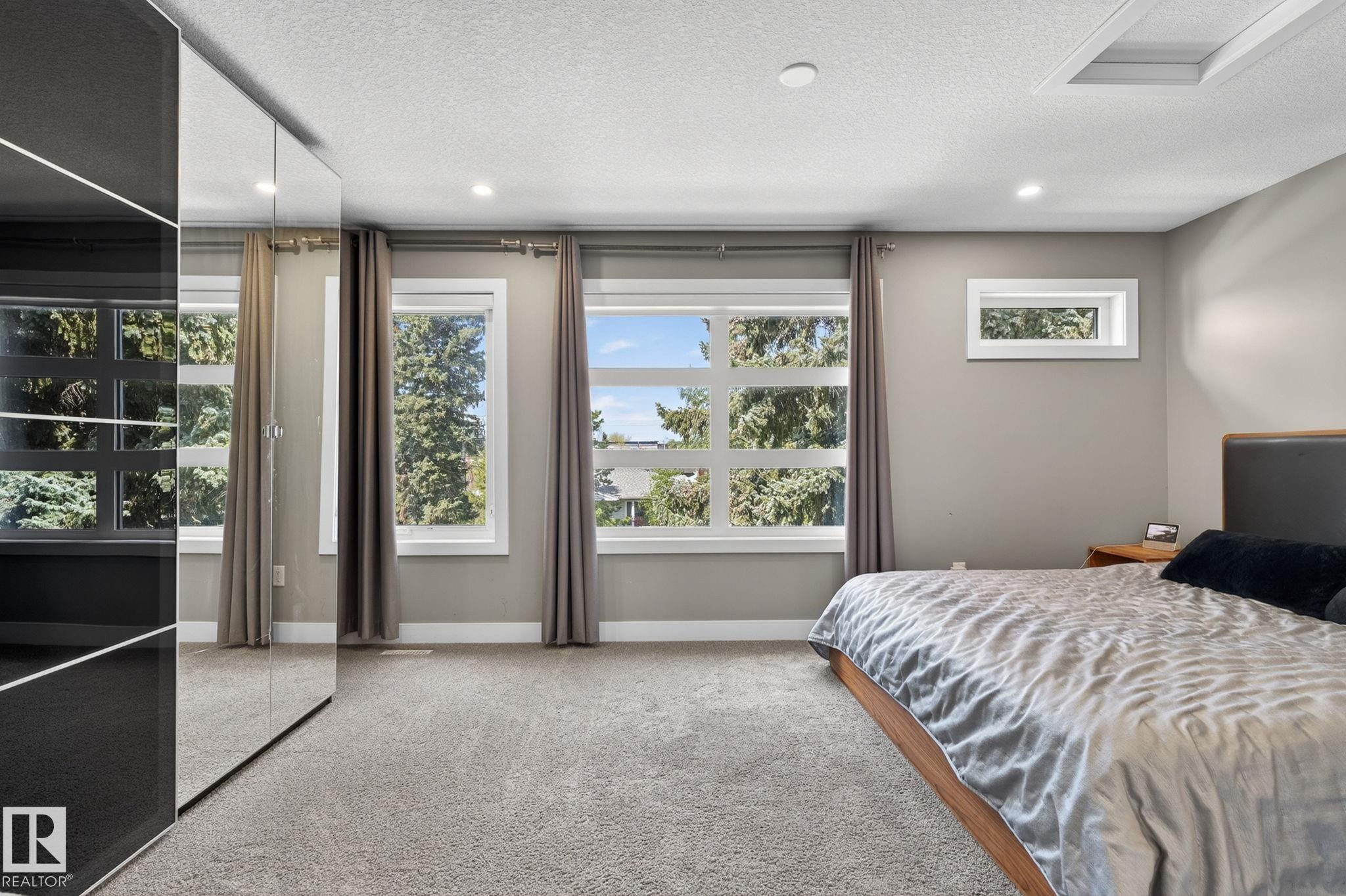 Wall-to-wall carpeting with multiple windows providing natural light - 8809 148 Street, Edmonton, AB - Indoor Photo Showing Bedroom