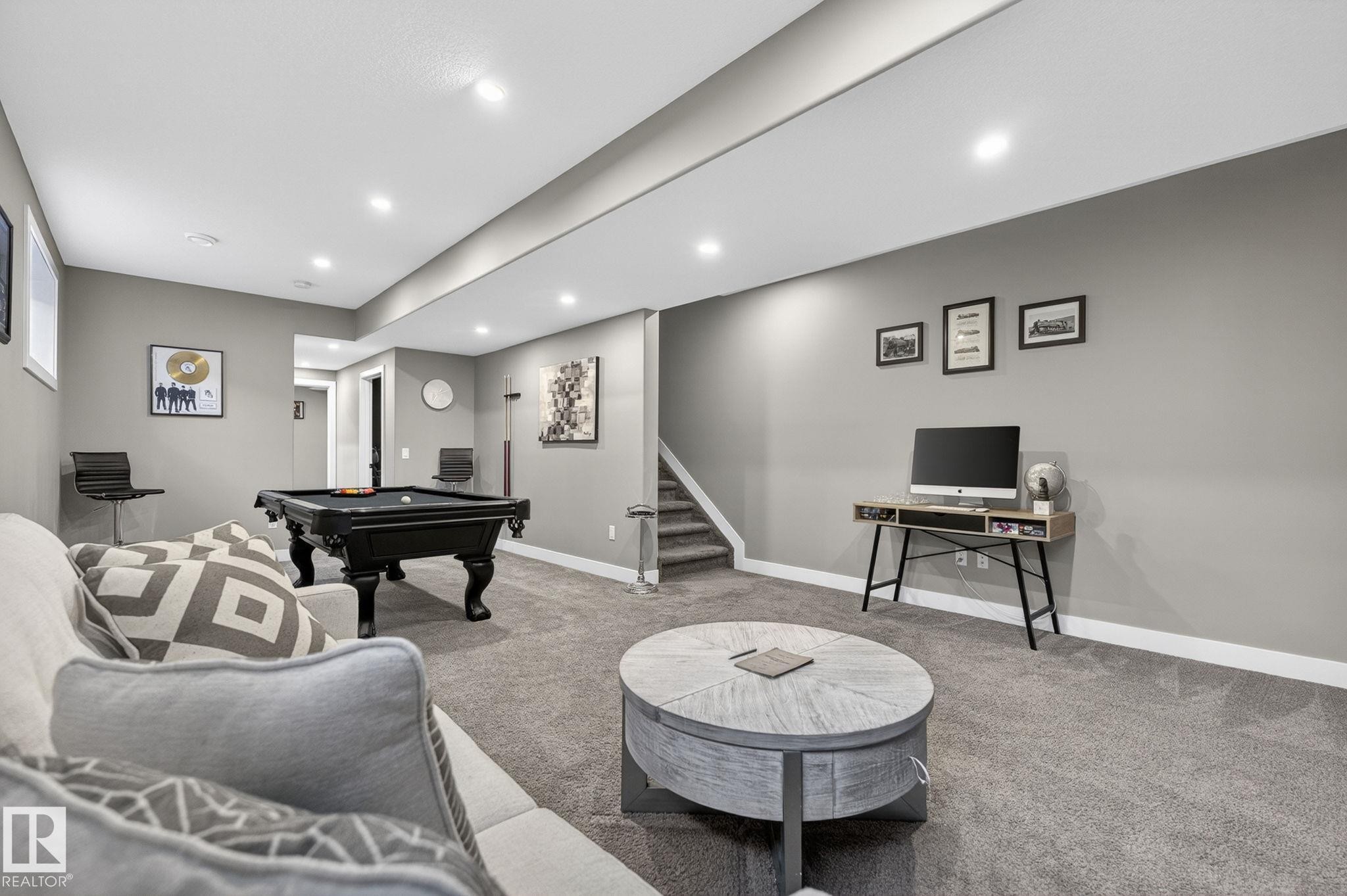 Expansive recreation area featuring recessed lighting, gray carpeting, white trim, and a staircase with a carpeted runner - 8809 148 Street, Edmonton, AB - Indoor