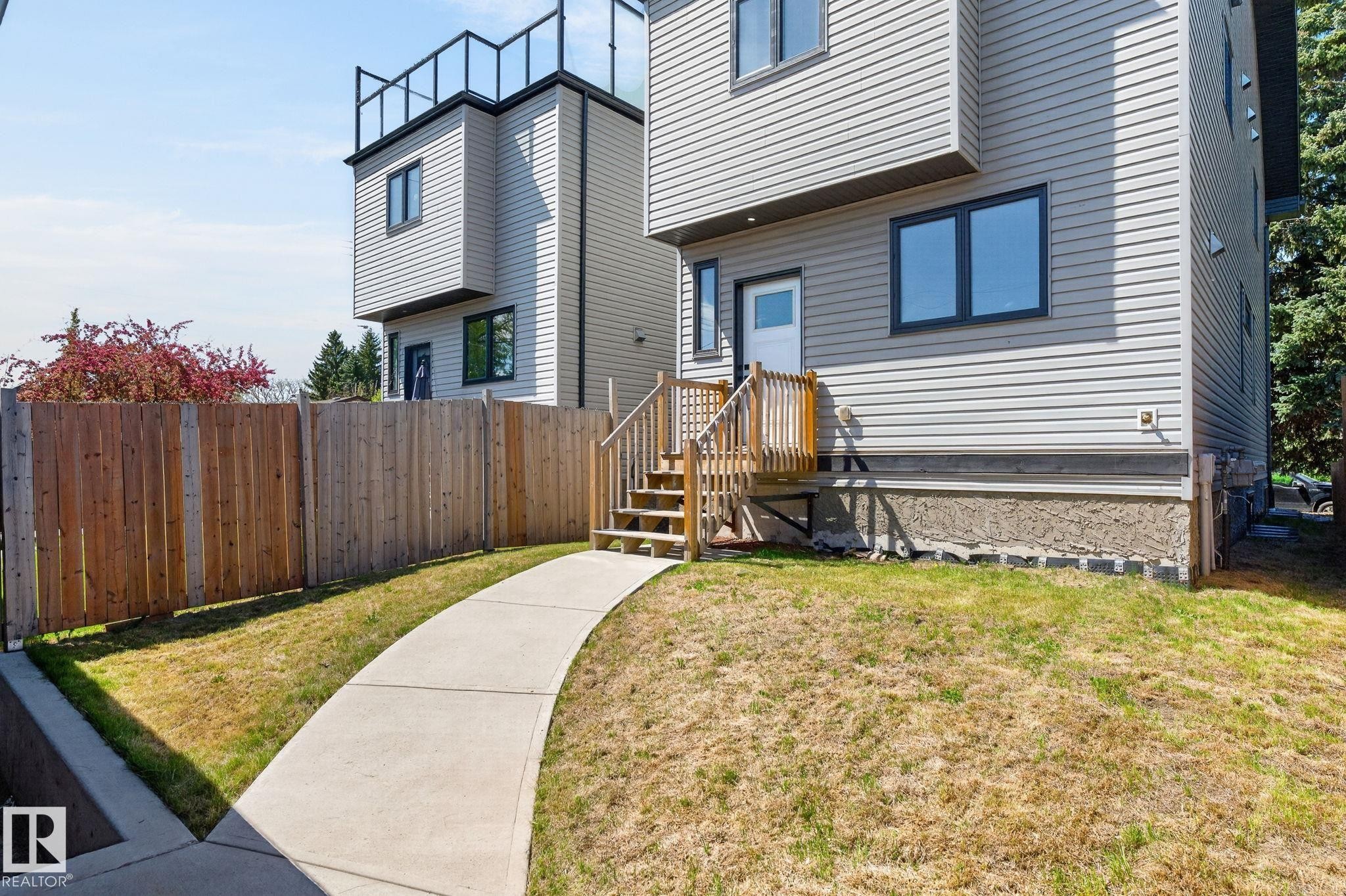 Contemporary multi-level residence featuring light gray siding and dark-trimmed windows - 8809 148 Street, Edmonton, AB - Outdoor