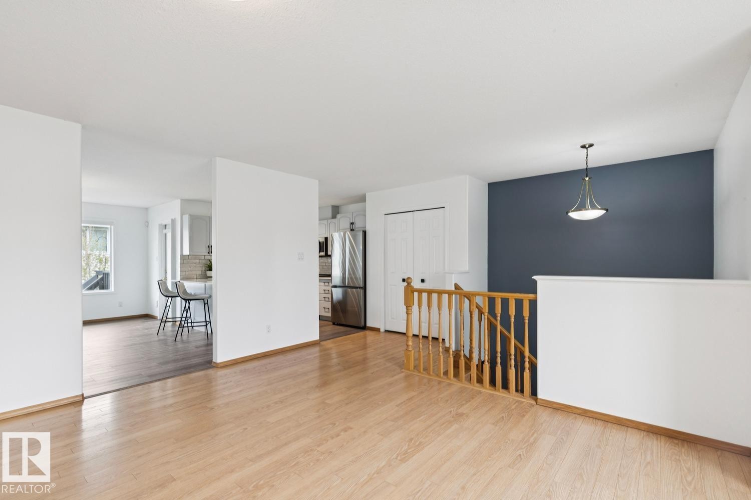 Hardwood-finish flooring extending through an open living area - 1 225 Blackburn Drive E, Edmonton, AB
