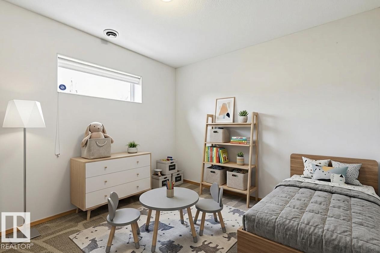 Bright room featuring a horizontal window, white walls, and wood-finish flooring - 1 225 Blackburn Drive E, Edmonton, AB