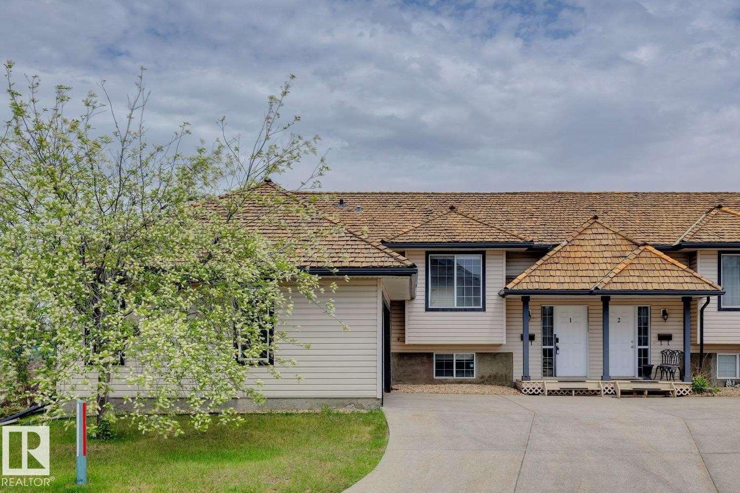 Multi-unit property with light-toned siding and cedar shake roofing - 1 225 Blackburn Drive E, Edmonton, AB