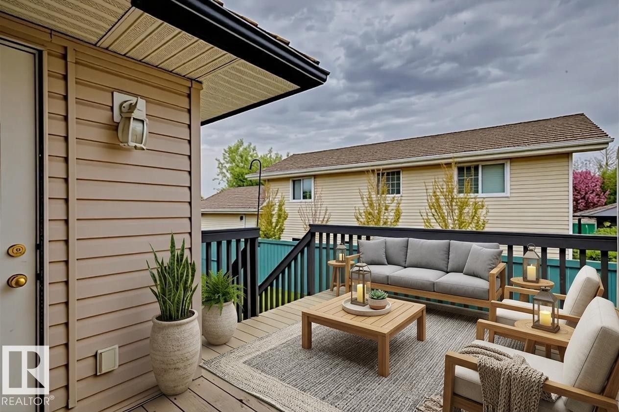 Expansive outdoor deck featuring wood-finish flooring, dark railings, and durable siding - 1 225 Blackburn Drive E, Edmonton, AB