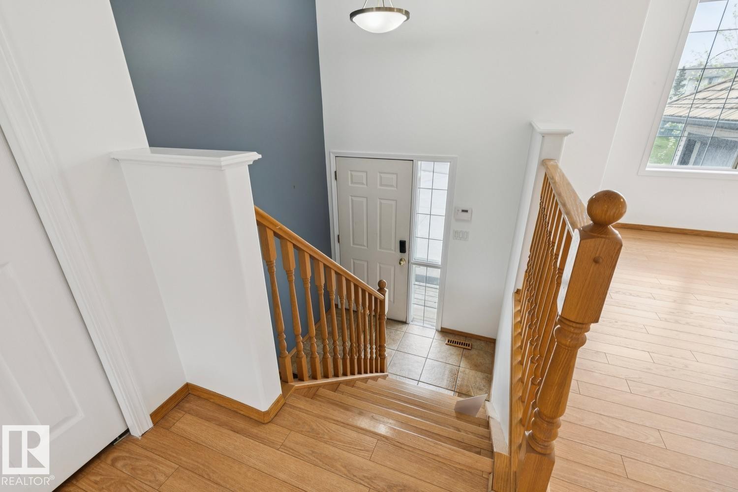 Light wood-finish flooring and staircase with natural wood railings - 1 225 Blackburn Drive E, Edmonton, AB