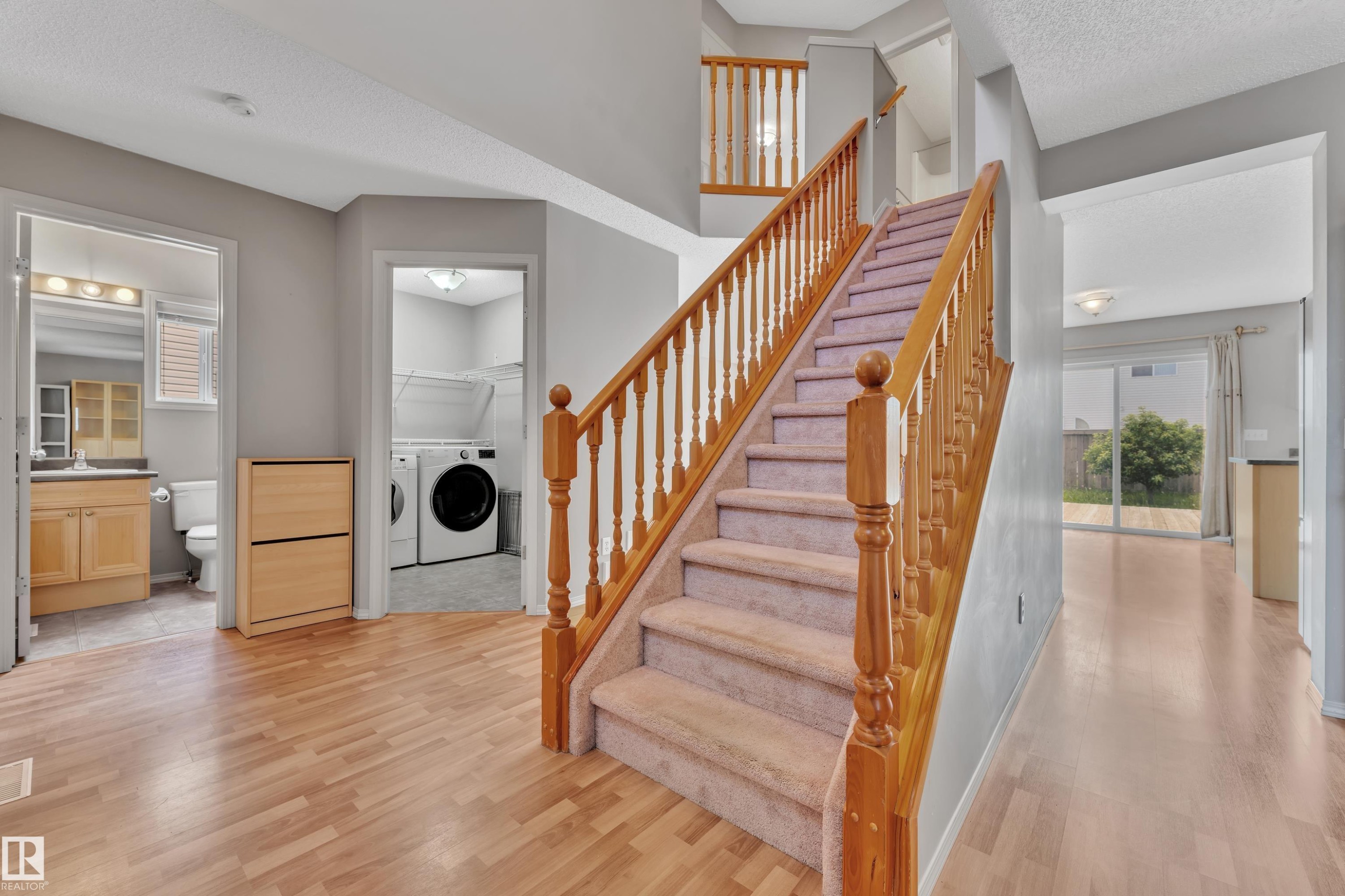 Central staircase with wood-finish handrail and carpeted treads - 14031 136 Street, Edmonton, AB
