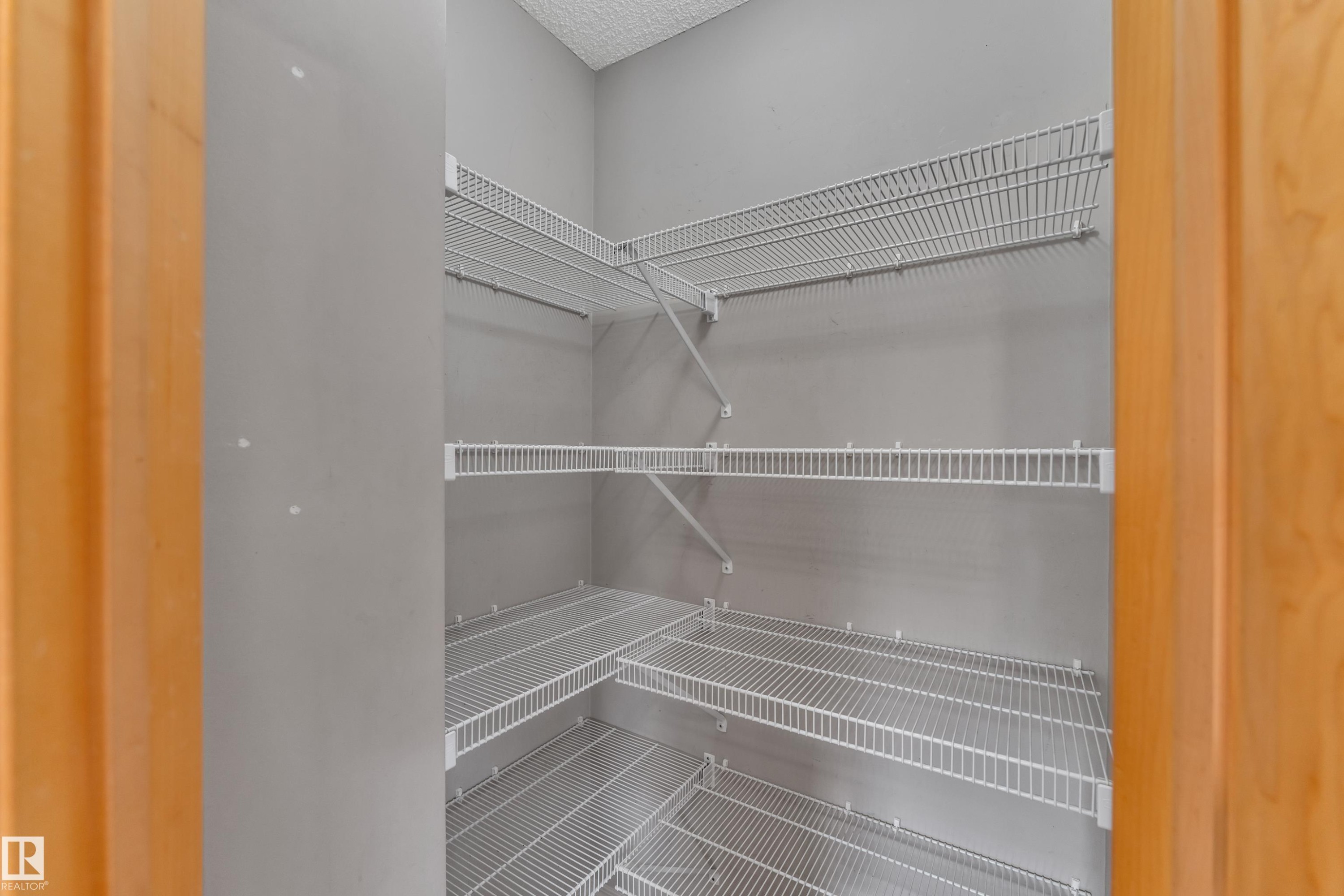 Corner walk-in pantry with light gray walls and white wire shelving - 14031 136 Street, Edmonton, AB