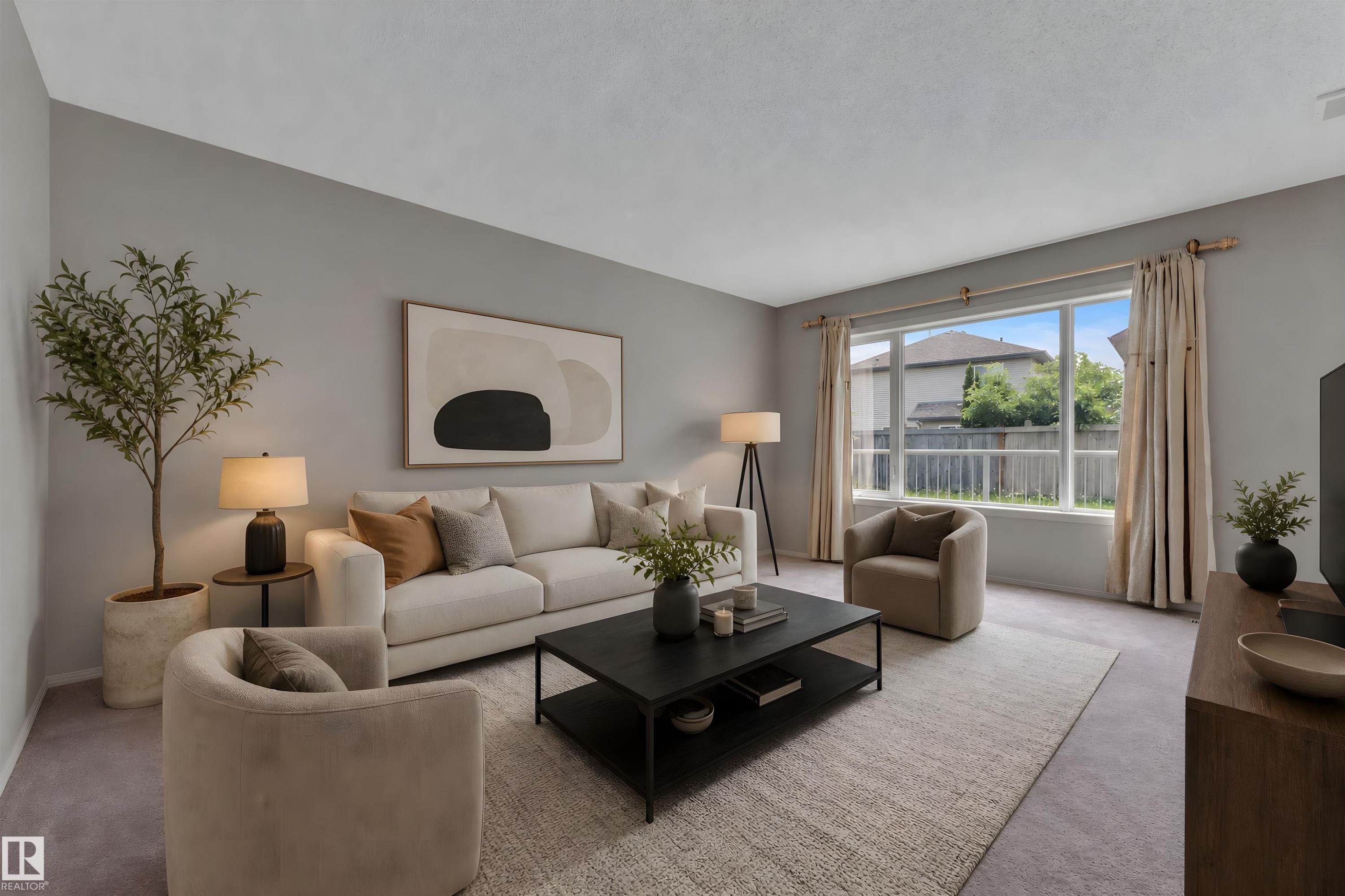 Bright living area featuring a large window, light-toned walls, and a textured carpet - 14031 136 Street, Edmonton, AB