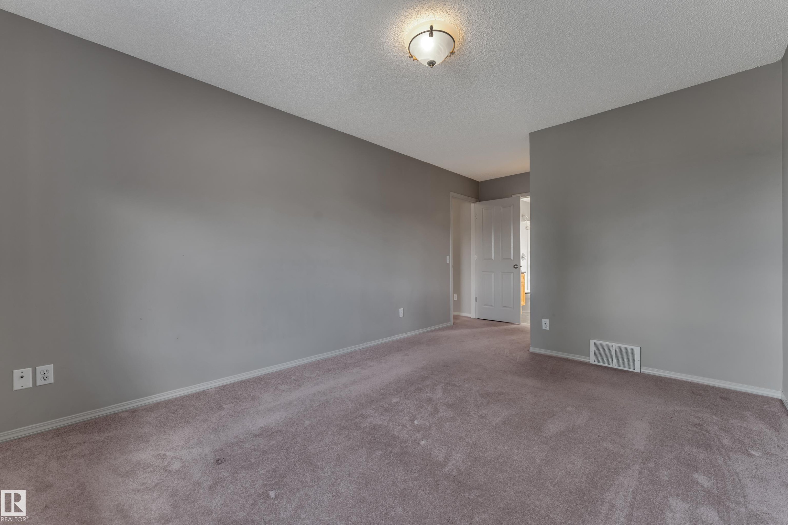 Interior room featuring gray painted walls, textured ceiling, and purple-hued carpet - 14031 136 Street, Edmonton, AB