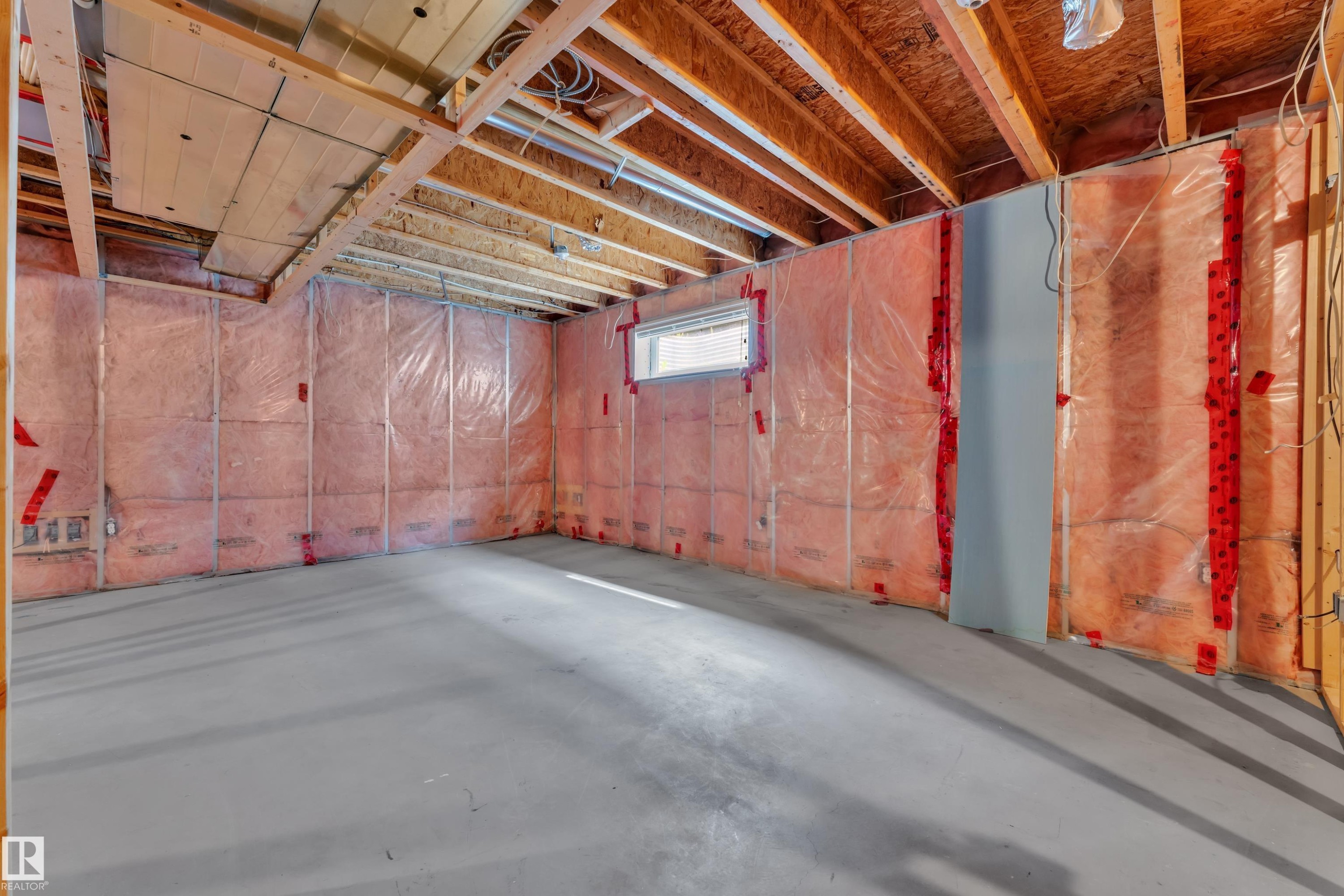 Unfinished basement space featuring exposed wood joists and subflooring, insulated perimeter walls, and a poured concrete floor - 14031 136 Street, Edmonton, AB