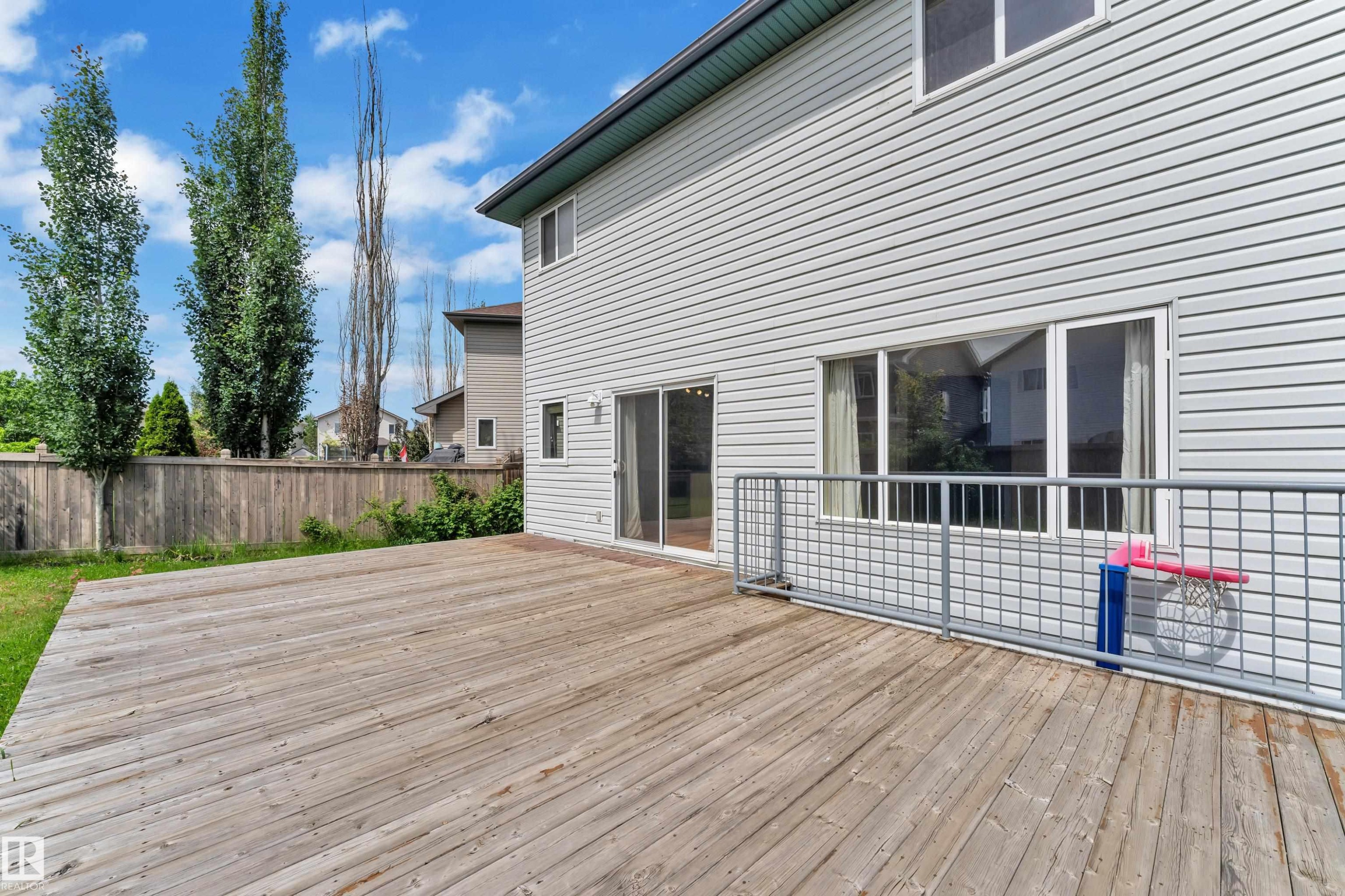 Expansive wood deck with a metal grid railing - 14031 136 Street, Edmonton, AB