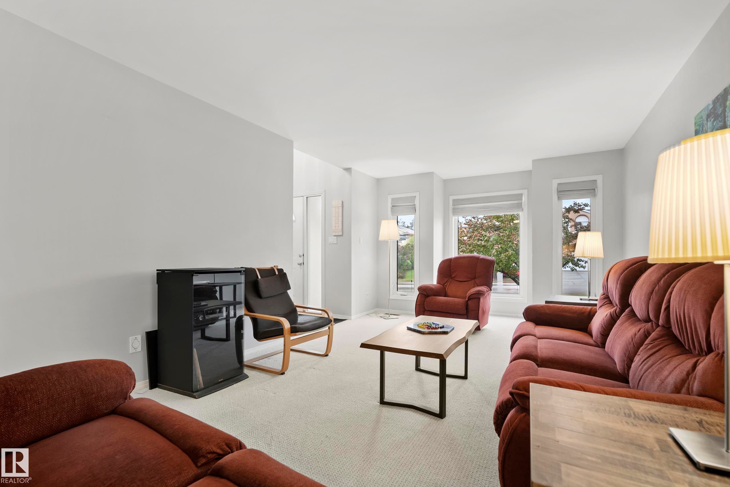 Living area featuring light gray walls, white ceiling, and light-toned carpet flooring - 15503 62 Street, Edmonton, AB