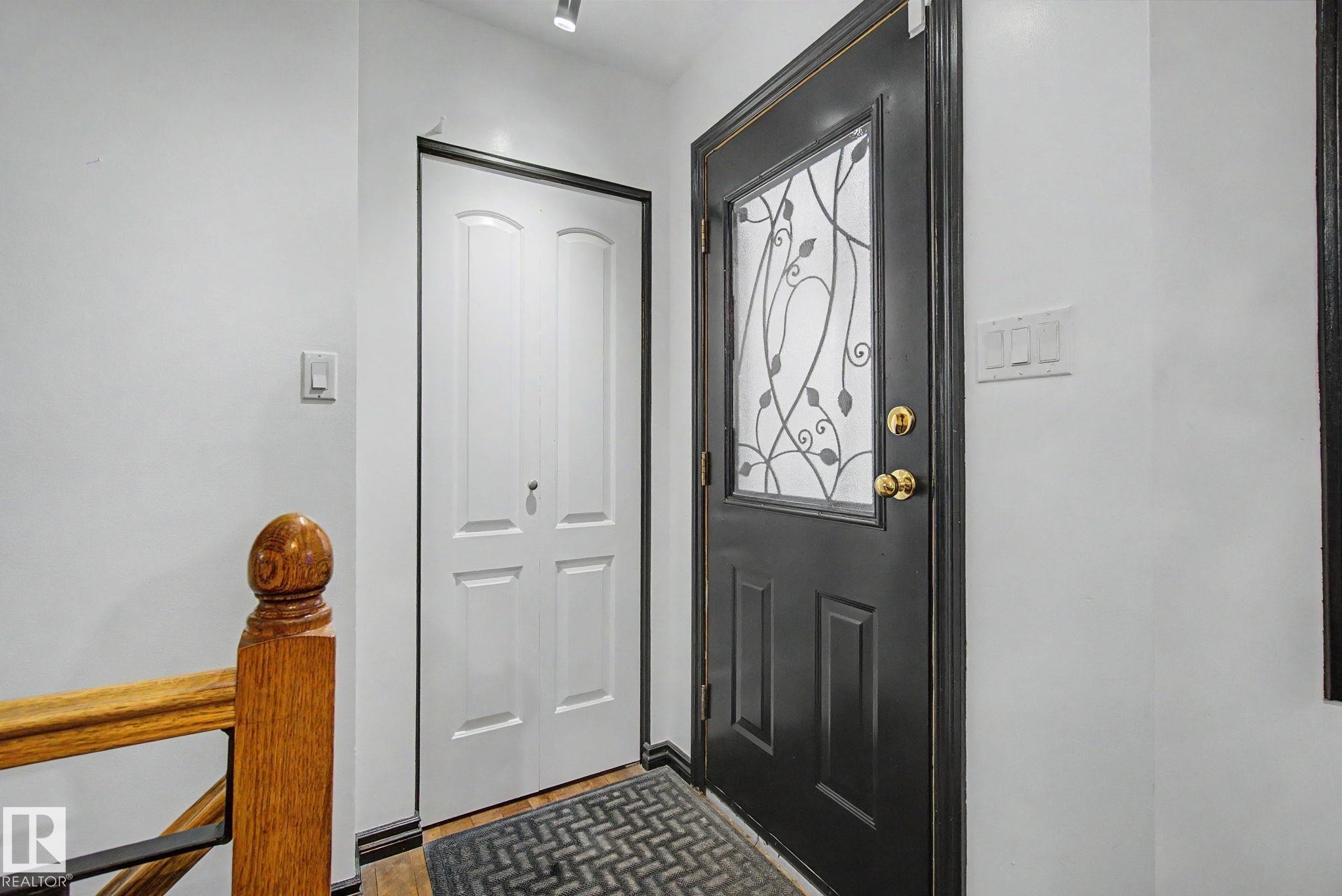 Black entry door with decorative glass insert - 242 Northmount Drive, Wetaskiwin, AB