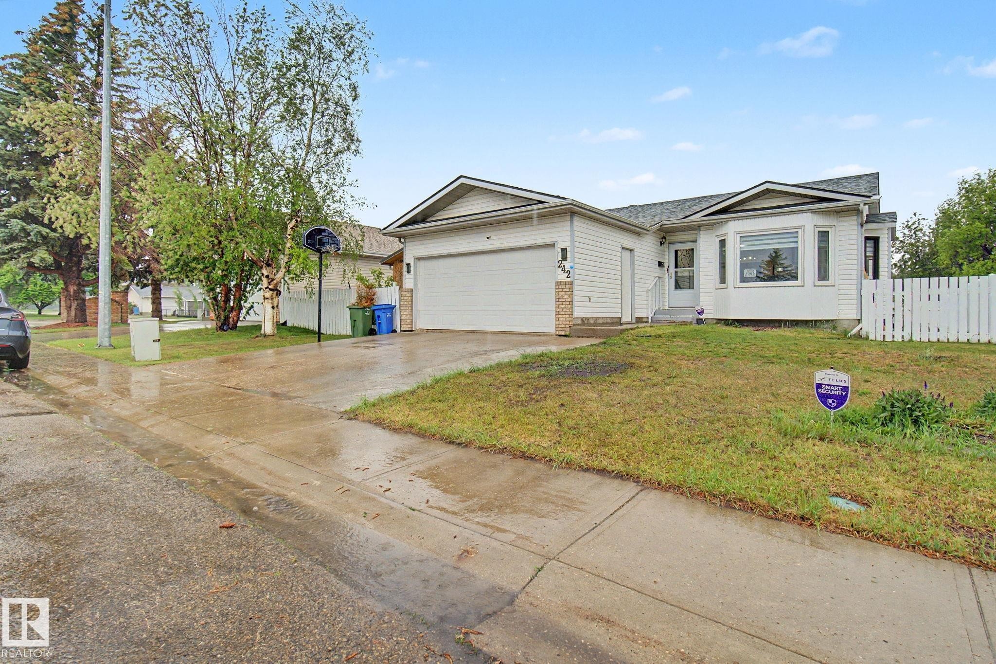 Ranch-style residence featuring white siding, a prominent bay window, and an attached garage - 242 Northmount Drive, Wetaskiwin, AB