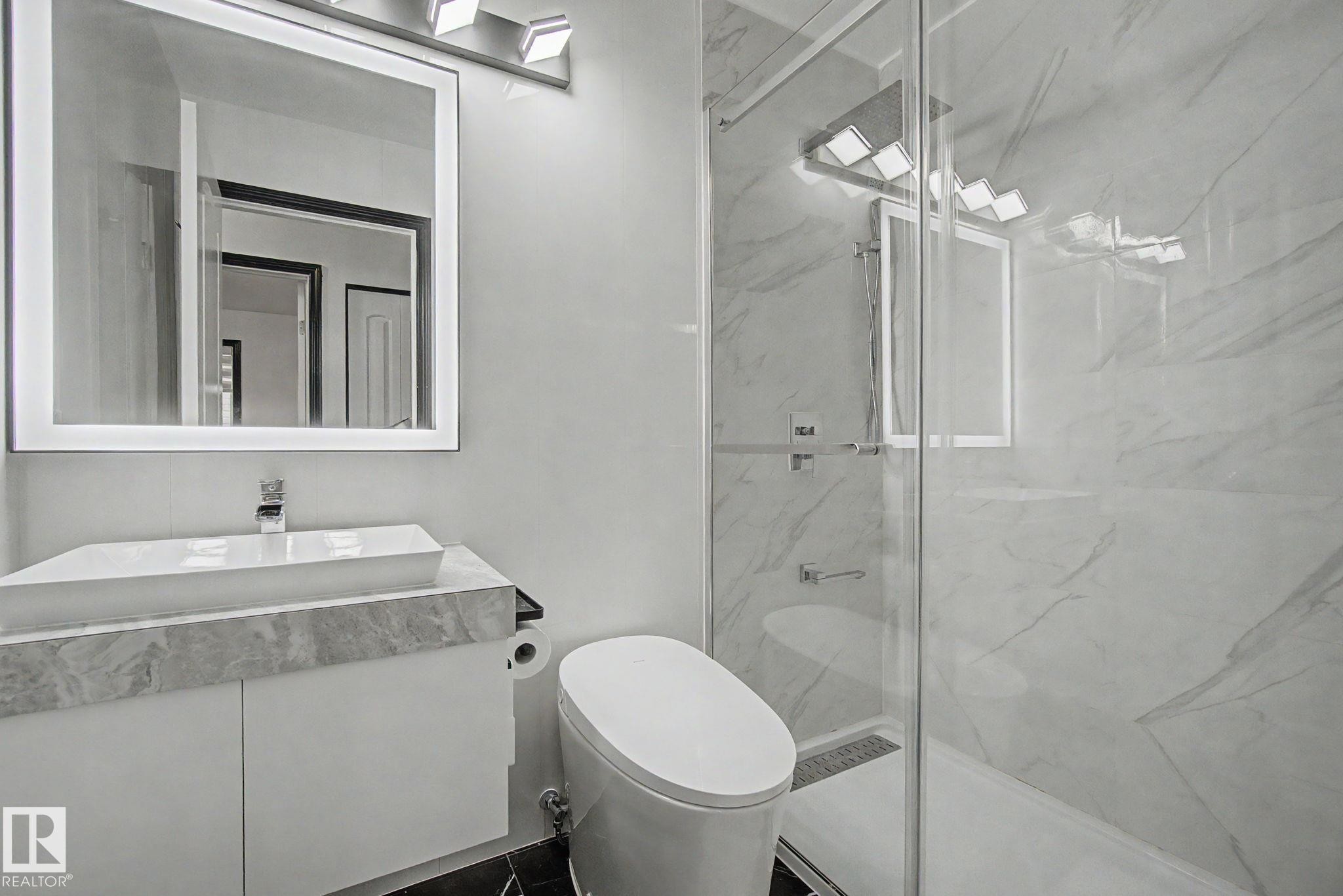 Contemporary bathroom featuring a floating vanity with a vessel sink, an illuminated mirror, and a walk-in shower with glass enclosure - 242 Northmount Drive, Wetaskiwin, AB