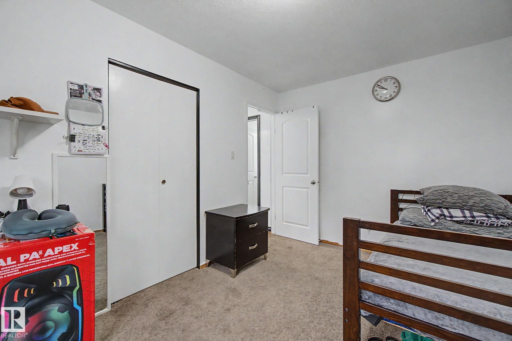 Neutral-toned carpet flooring with white walls and a white interior door - 242 Northmount Drive, Wetaskiwin, AB