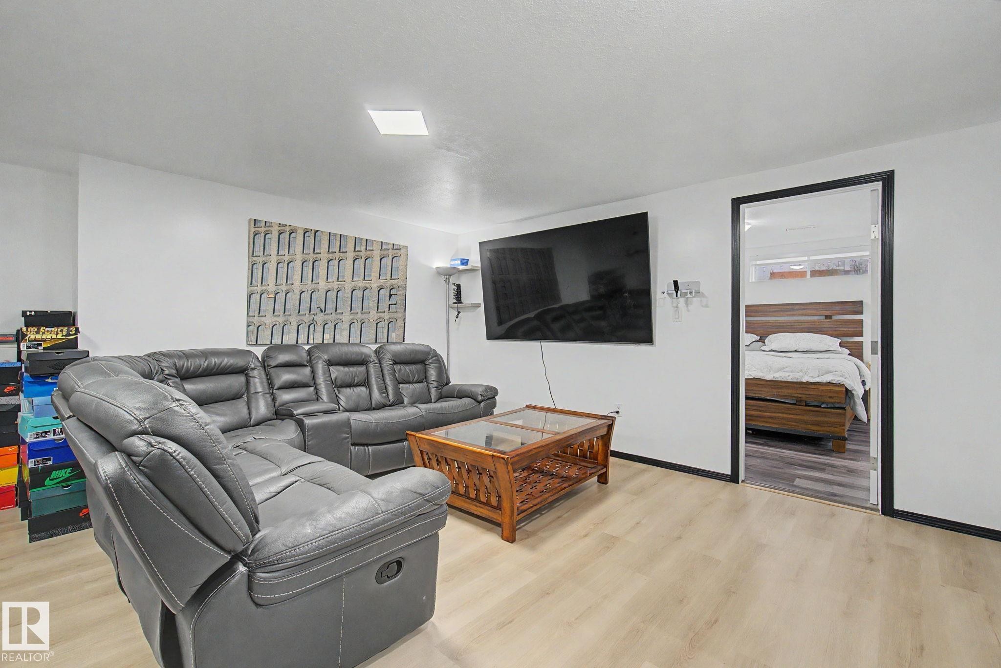Spacious room featuring light wood-finish flooring, white walls, and a recessed ceiling light - 242 Northmount Drive, Wetaskiwin, AB