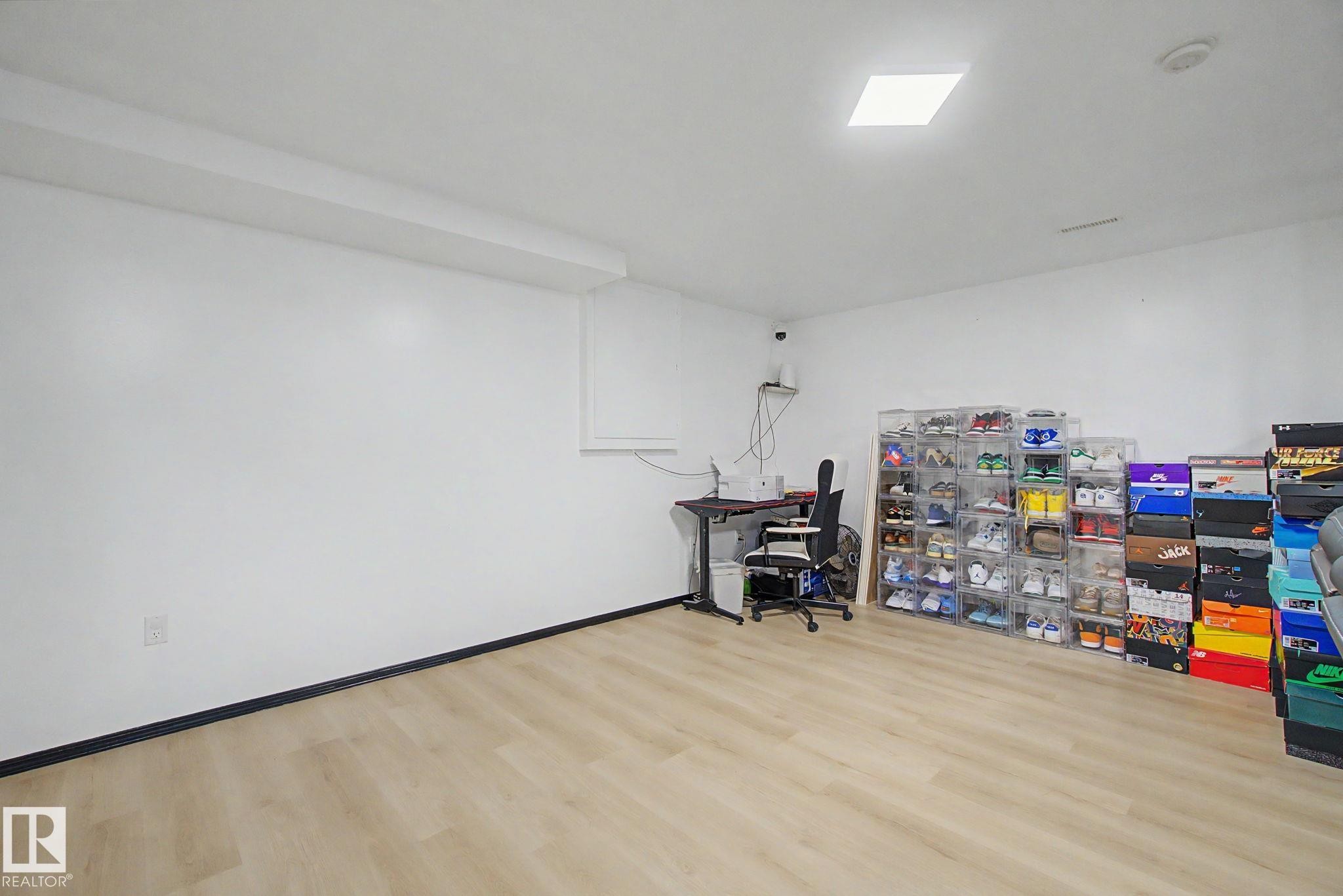 Spacious room featuring light wood-finish flooring, white painted walls, and a recessed ceiling light - 242 Northmount Drive, Wetaskiwin, AB