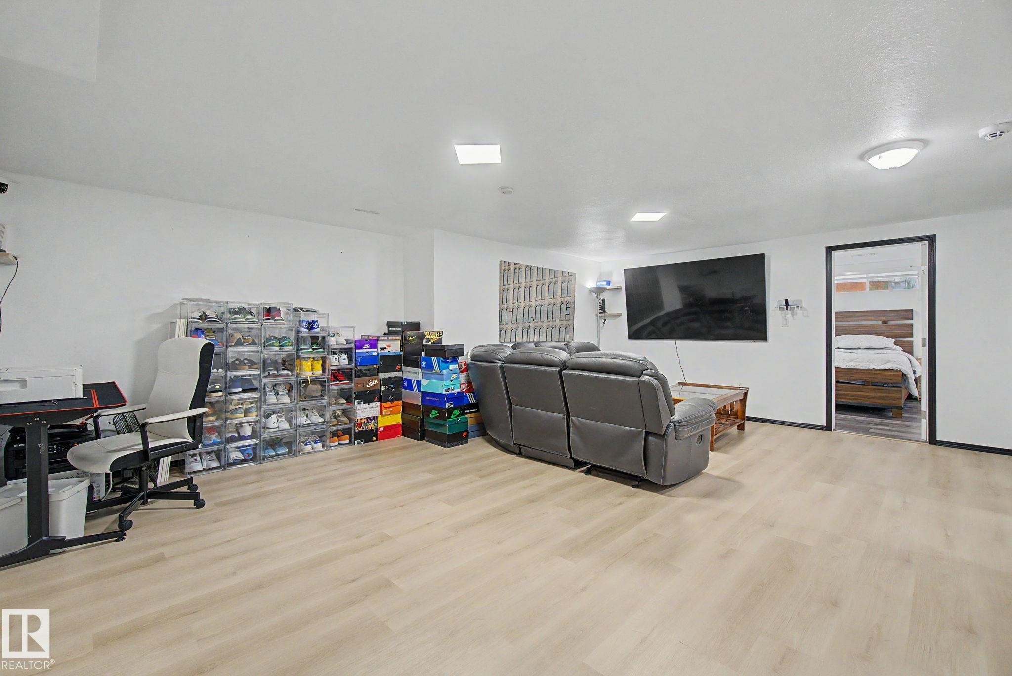 Spacious room featuring light wood-finish flooring, white walls, and recessed lighting - 242 Northmount Drive, Wetaskiwin, AB