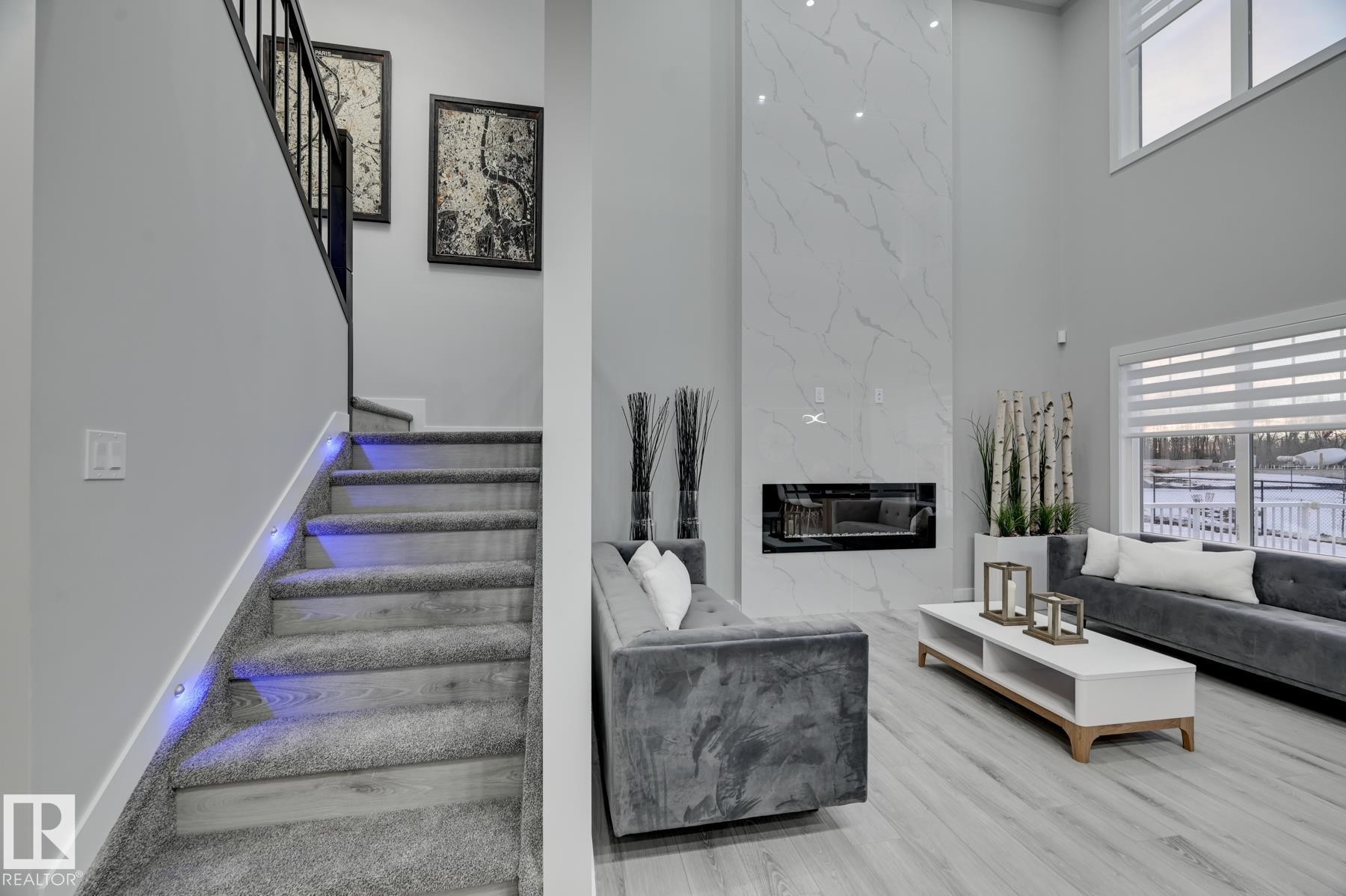 Two-story living area with a floor-to-ceiling fireplace featuring a linear electric insert - 54 Chartres Close, St. Albert, AB - Indoor With Fireplace