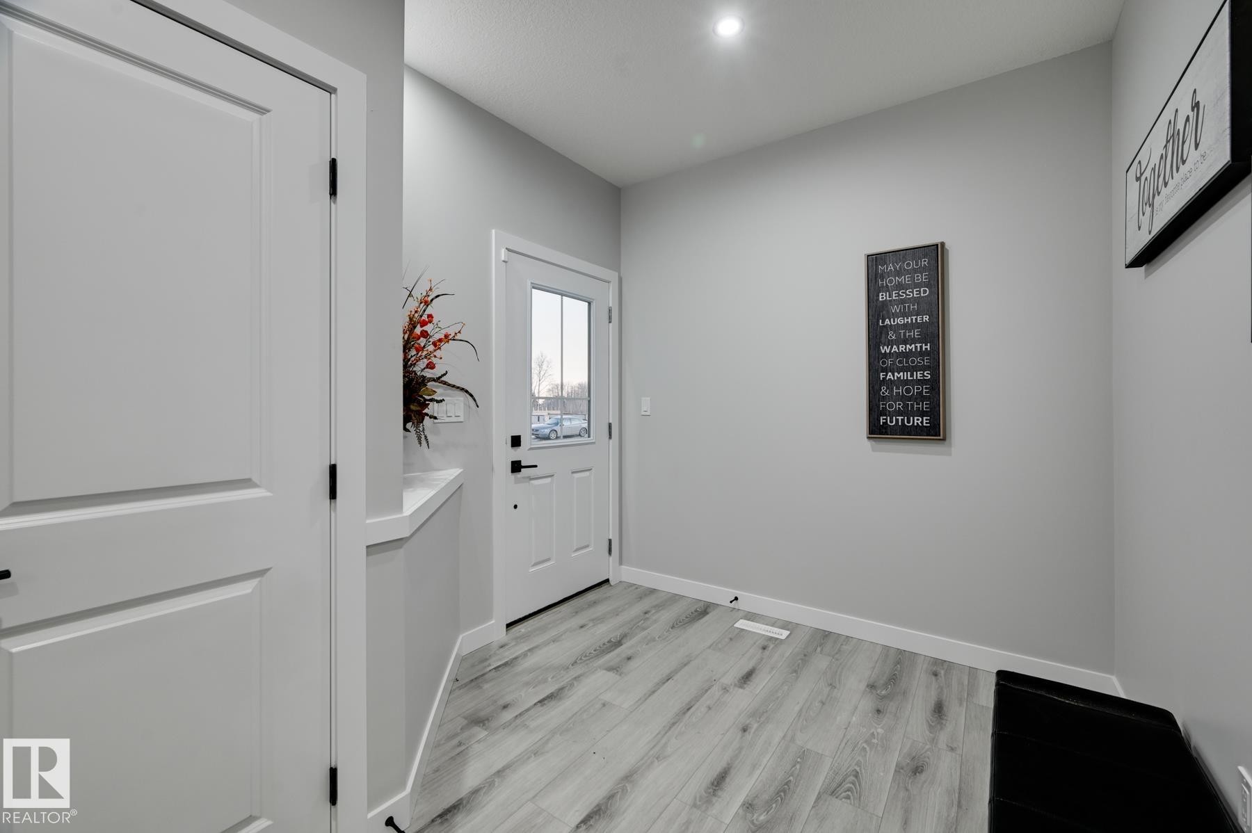 Entryway featuring light wood-finish flooring, a white door with clear glass panels, recessed lighting, and crisp white trim - 54 Chartres Close, St. Albert, AB - Indoor Photo Showing Other Room
