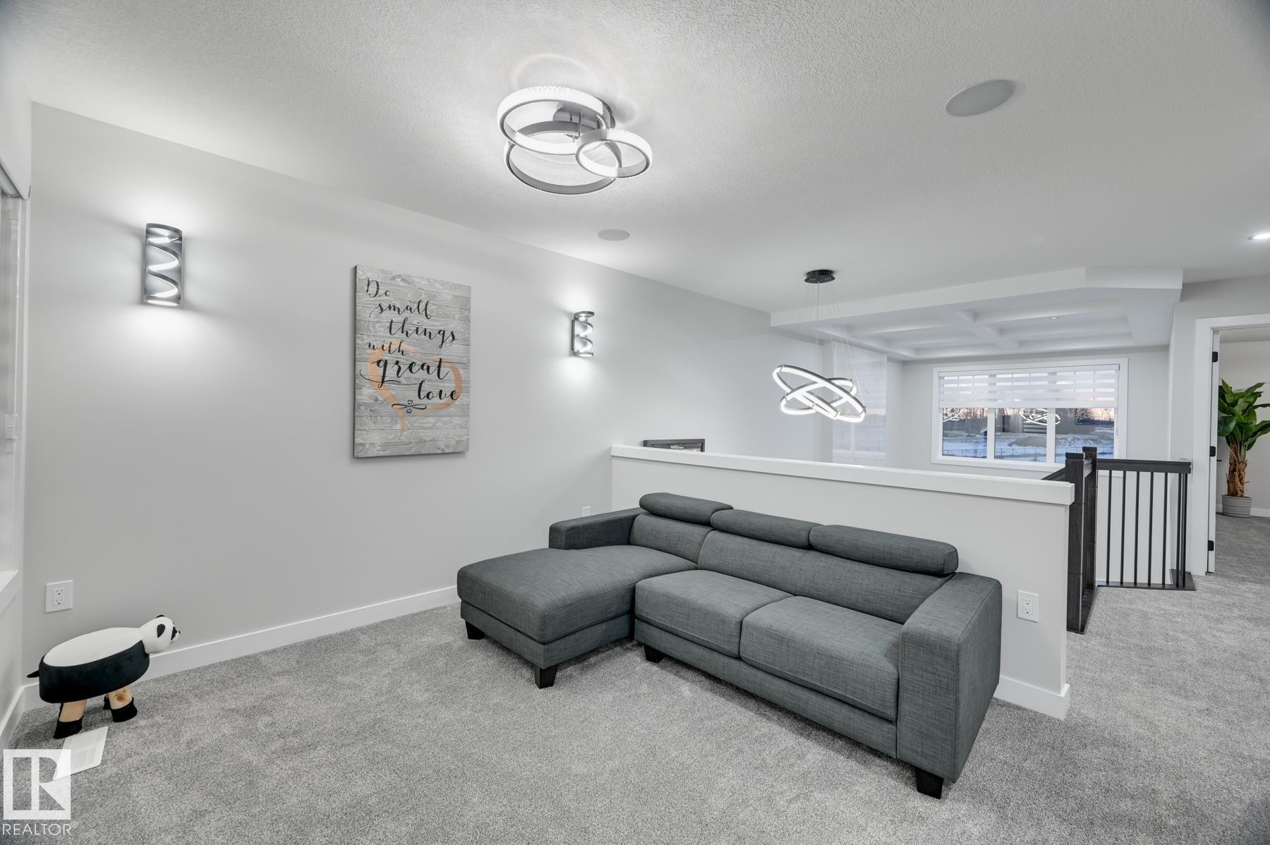 Carpeted open-concept bonus room featuring contemporary overhead lighting, wall sconces, and recessed lighting - 54 Chartres Close, St. Albert, AB - Indoor