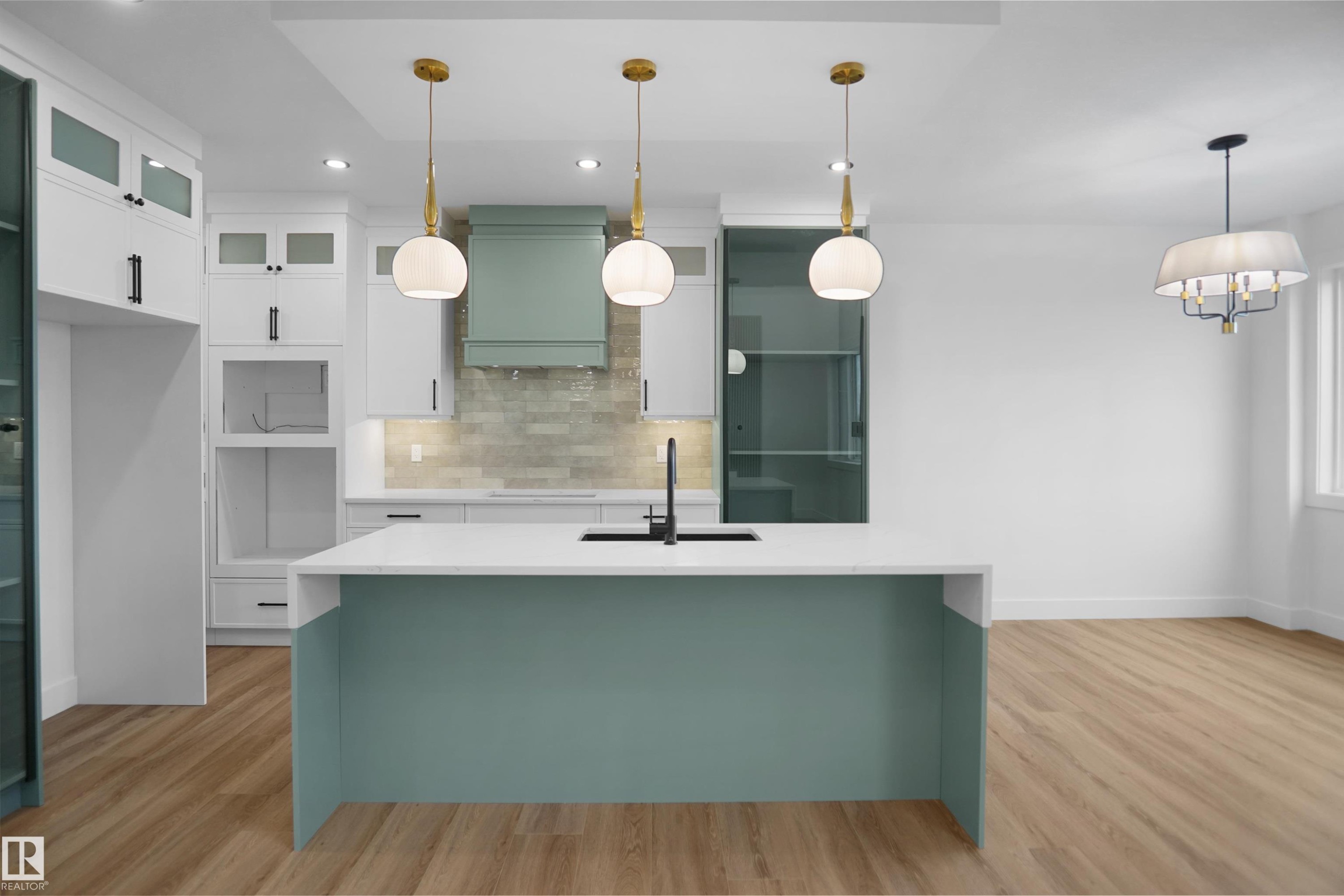 Modern kitchen featuring a spacious island with a white countertop and contrasting teal base - 142 Edgewater Circle, Leduc, AB
