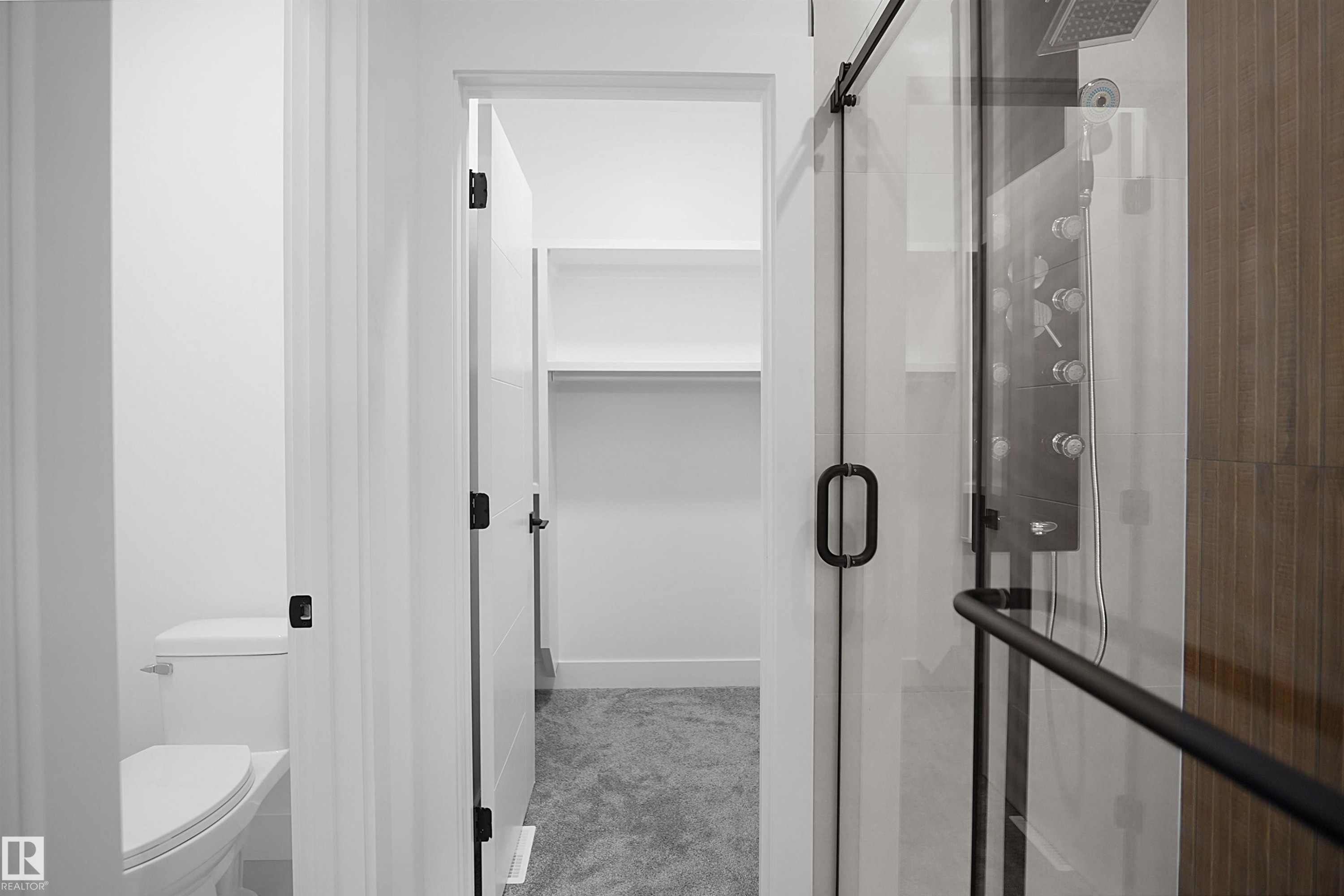 Walk-in shower with clear glass enclosure and black hardware - 142 Edgewater Circle, Leduc, AB