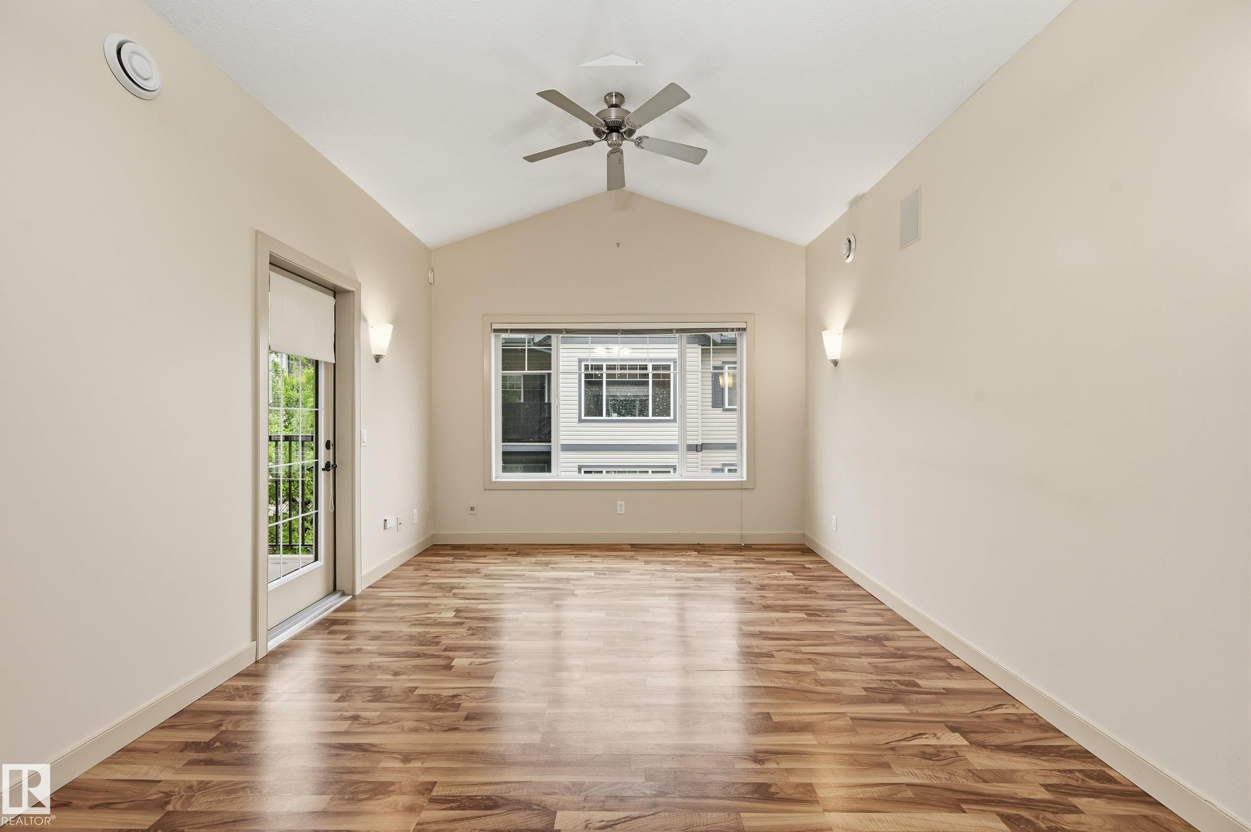 Open concept room featuring wood-finish flooring, a vaulted ceiling, and a ceiling fan - 50 2565 Hanna Crescent, Edmonton, AB