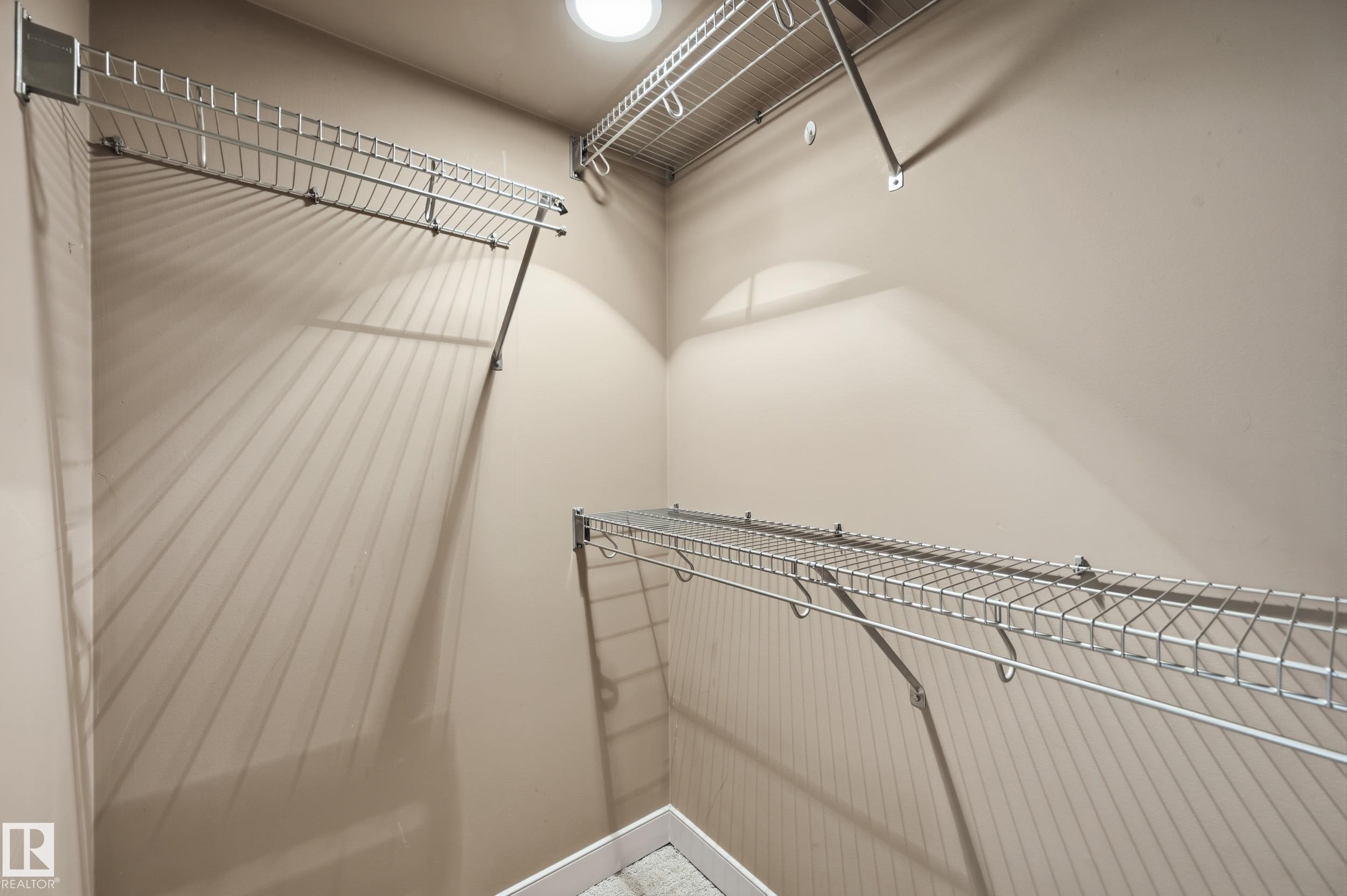 Walk-in closet featuring light-colored walls, recessed ceiling lighting, and multiple levels of wire shelving for storage - 50 2565 Hanna Crescent, Edmonton, AB