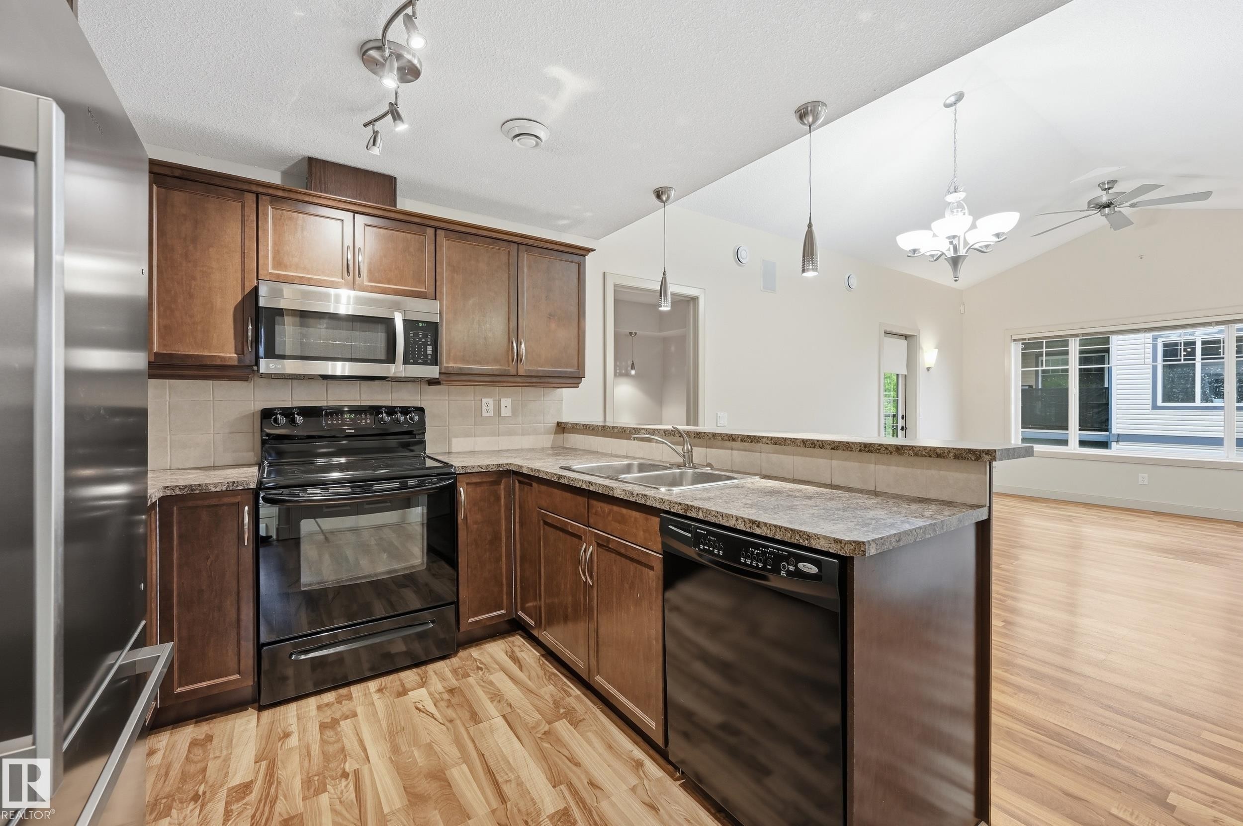 Kitchen with wood-finish flooring and dark wood cabinetry - 50 2565 Hanna Crescent, Edmonton, AB