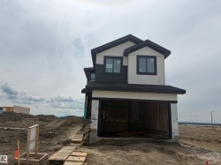 New construction residence featuring contemporary dark siding and white vertical paneling -
