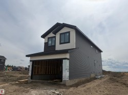 Newly constructed residence featuring dark gray horizontal siding and contrasting light vertical siding -