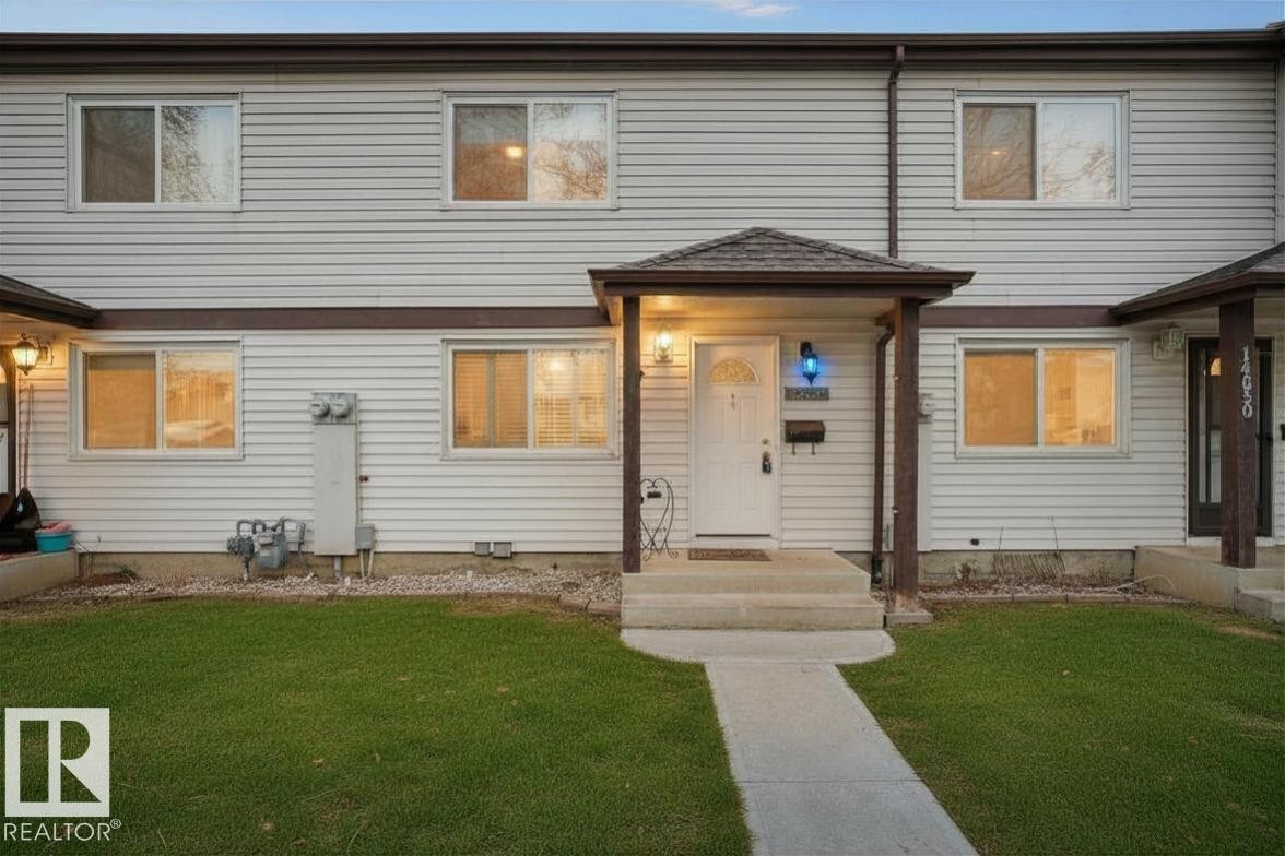 Townhome exterior featuring light-colored horizontal siding and dark trim - 14648 54 Street, Edmonton, AB
