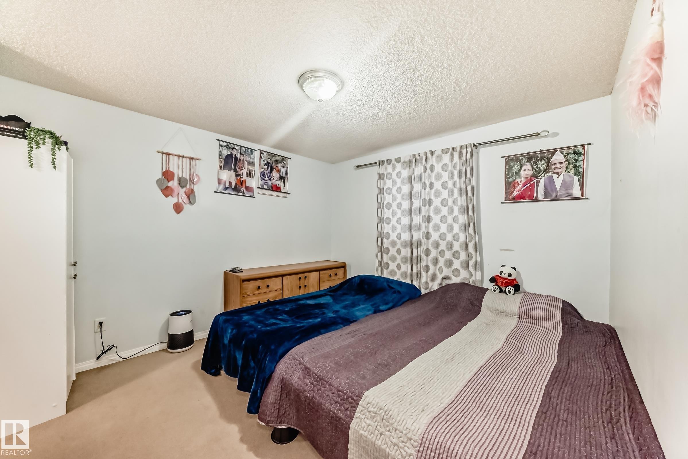 Carpeted room with light blue walls and a textured ceiling - 108 10535 122 Street, Edmonton, AB