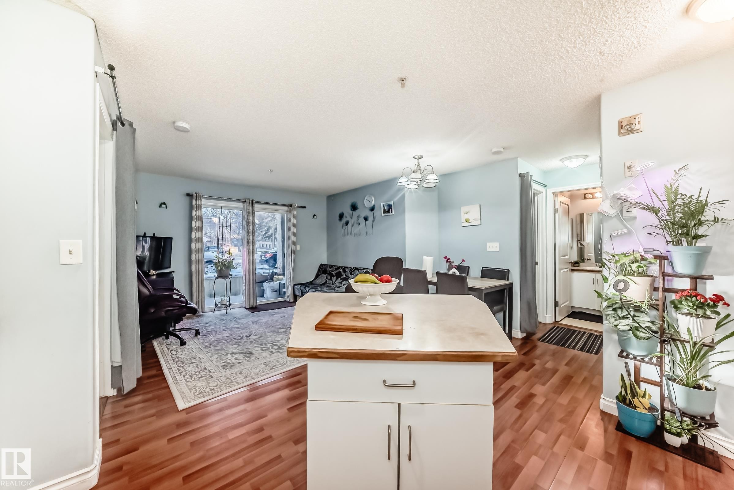 Kitchen island with a laminate countertop and white base cabinetry - 108 10535 122 Street, Edmonton, AB