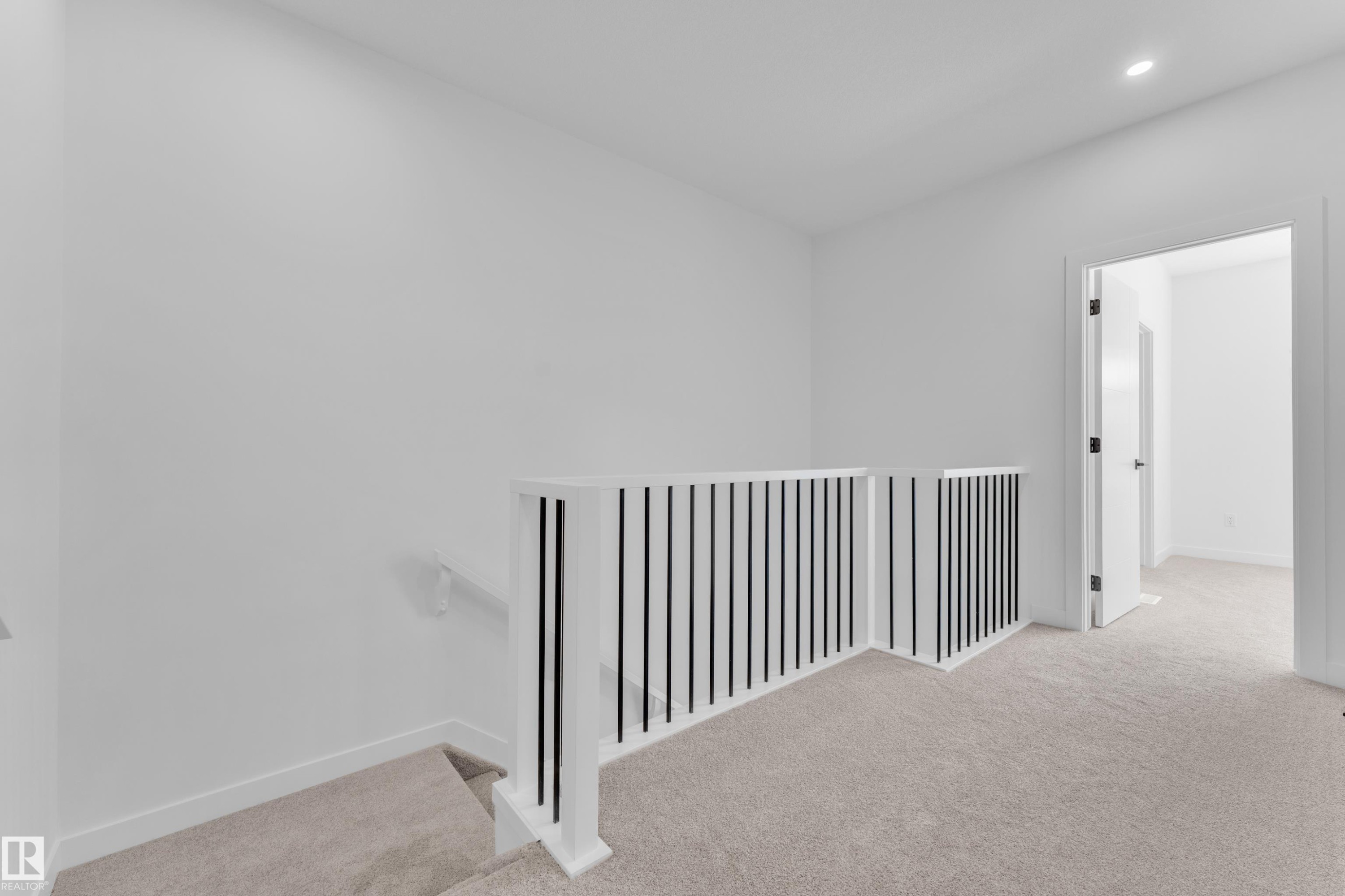 Upper landing featuring plush carpet flooring and modern railing with white balusters and black spindles - 177 Graybriar Drive, Stony Plain, AB