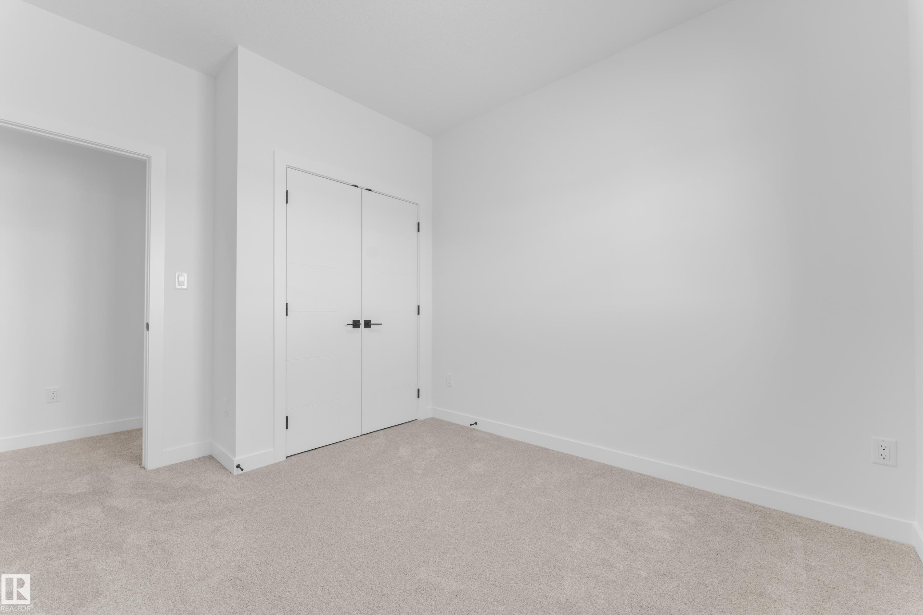 Plush neutral-toned carpeting extends throughout this room, complemented by white walls and trim - 177 Graybriar Drive, Stony Plain, AB