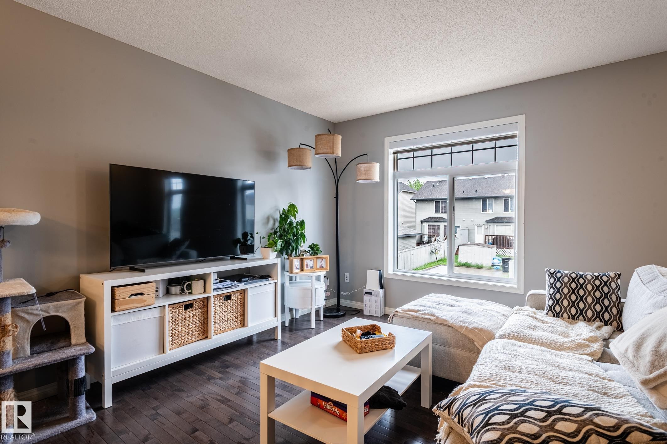 Living area featuring dark wood-finish flooring and light gray painted walls - 46 465 Hemingway Road, Edmonton, AB