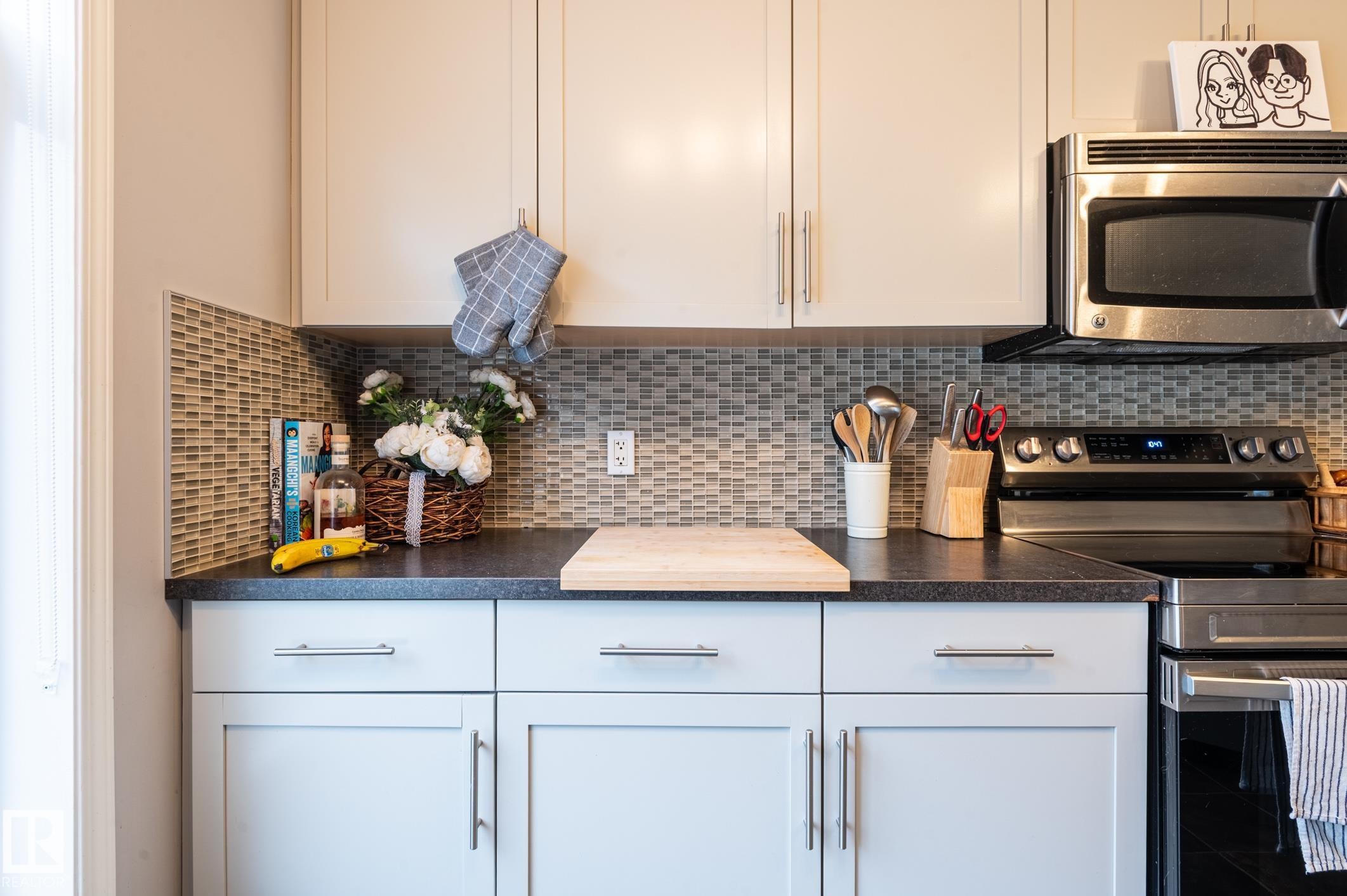 Kitchen featuring light-toned upper cabinetry, light gray lower cabinetry, and stainless steel hardware - 46 465 Hemingway Road, Edmonton, AB