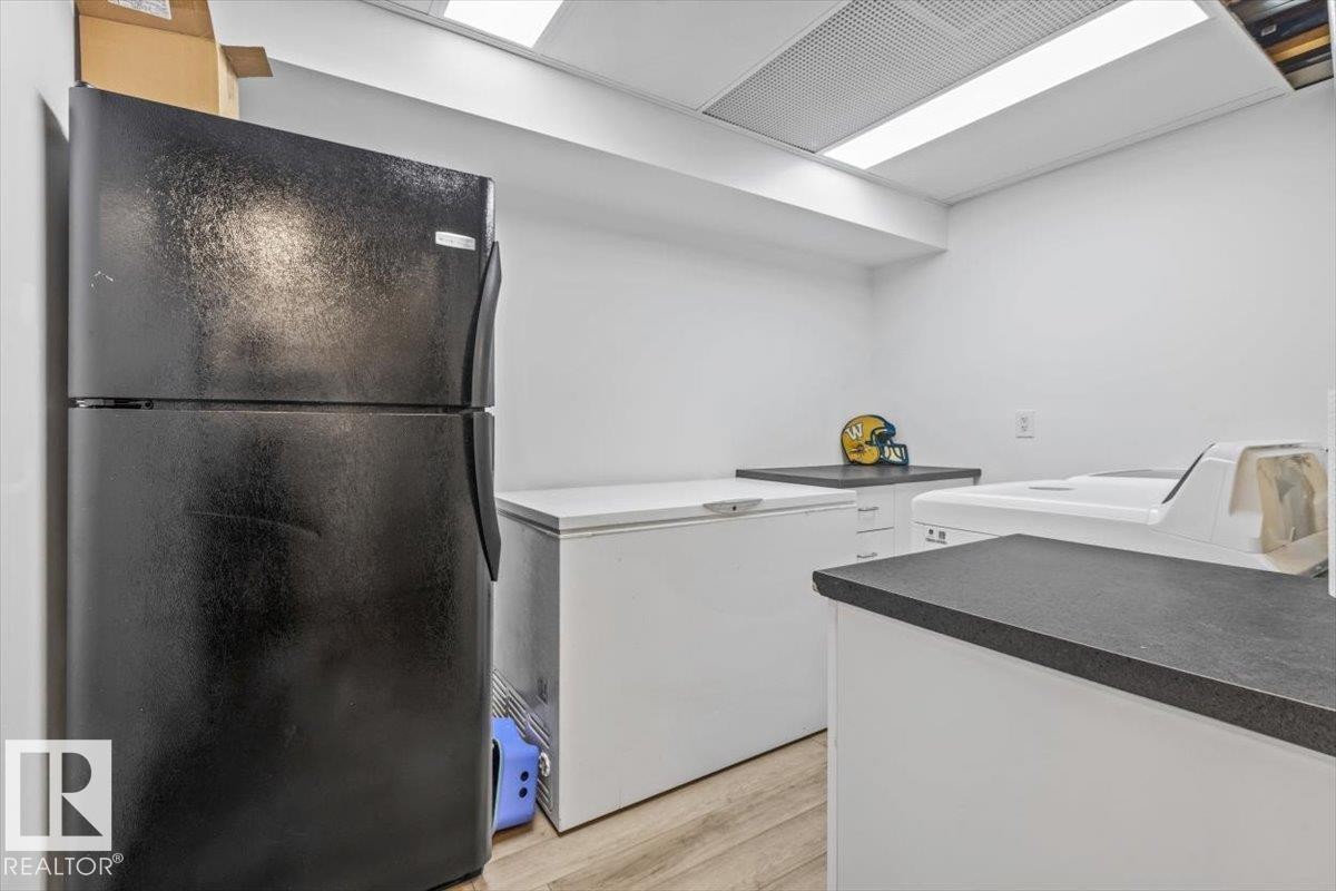Utility room featuring wood-finish flooring, white walls, and a recessed ceiling light fixture - 229 41 Summerwood Boulevard, Sherwood Park, AB - Indoor