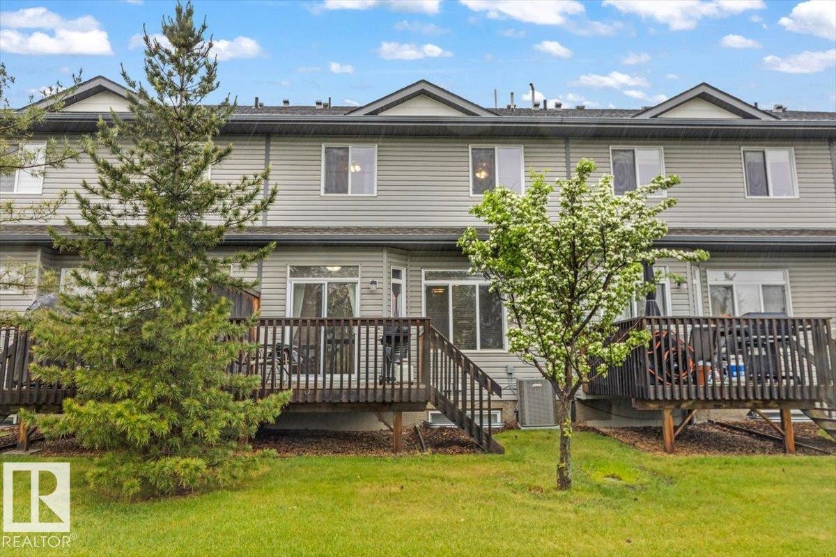 Rear exterior featuring two levels of siding, multiple windows, and two private wooden decks with railings - 229 41 Summerwood Boulevard, Sherwood Park, AB - Outdoor With Deck Patio Veranda