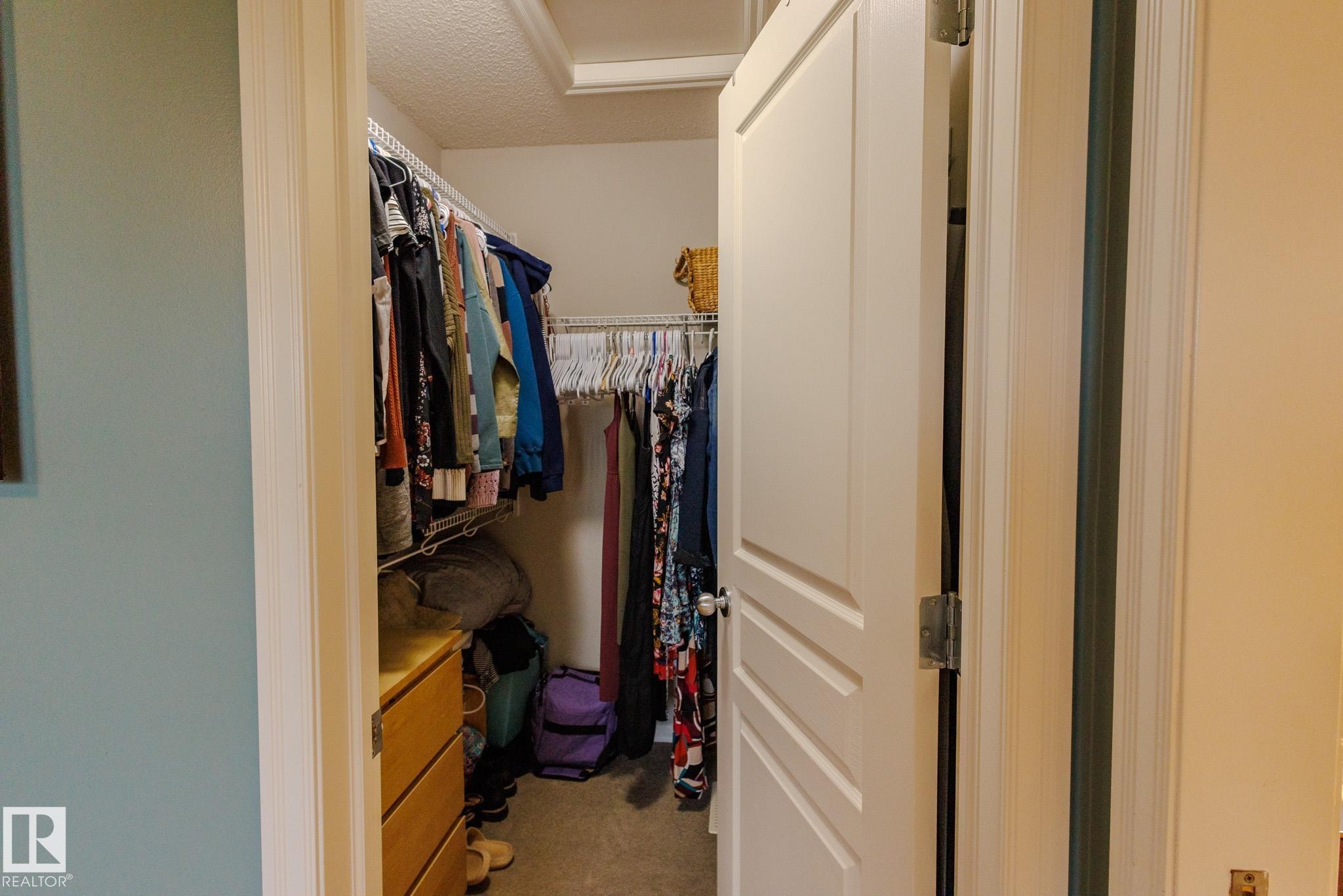 Walk-in closet featuring wire shelving, hanging rods, and a wood-finish drawer unit - 7207 14A Avenue, Edmonton, AB - Indoor With Storage