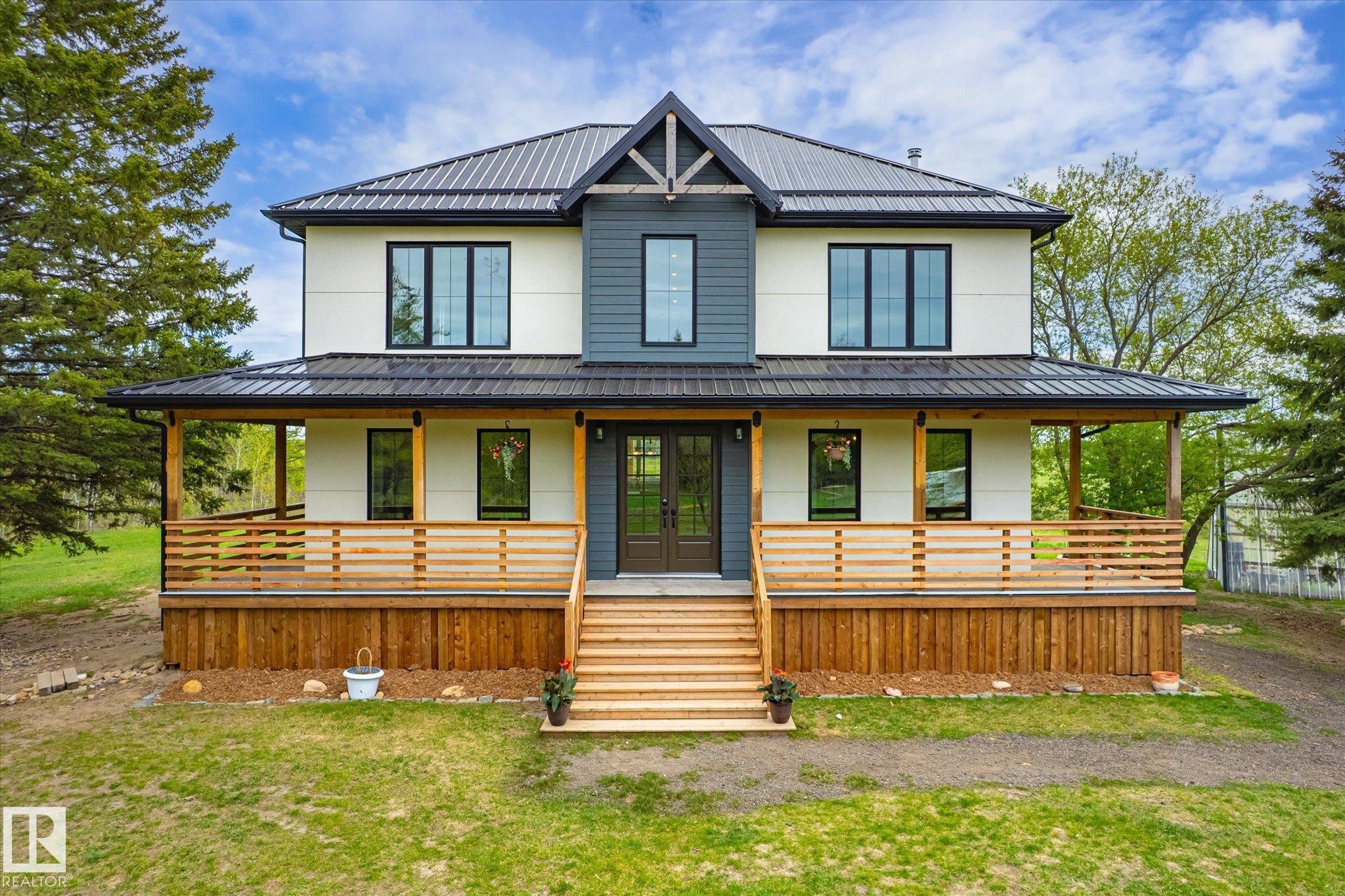 Contemporary two-story residence featuring a dark metal roof, white and charcoal siding, and black-framed windows - 59102 Rge Road 234, Rural Westlock County, AB