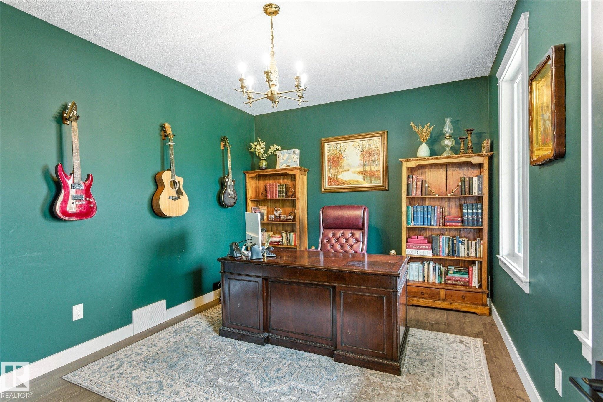 Dedicated office space featuring rich green walls, wood-finish flooring, and a decorative area rug - 59102 Rge Road 234, Rural Westlock County, AB