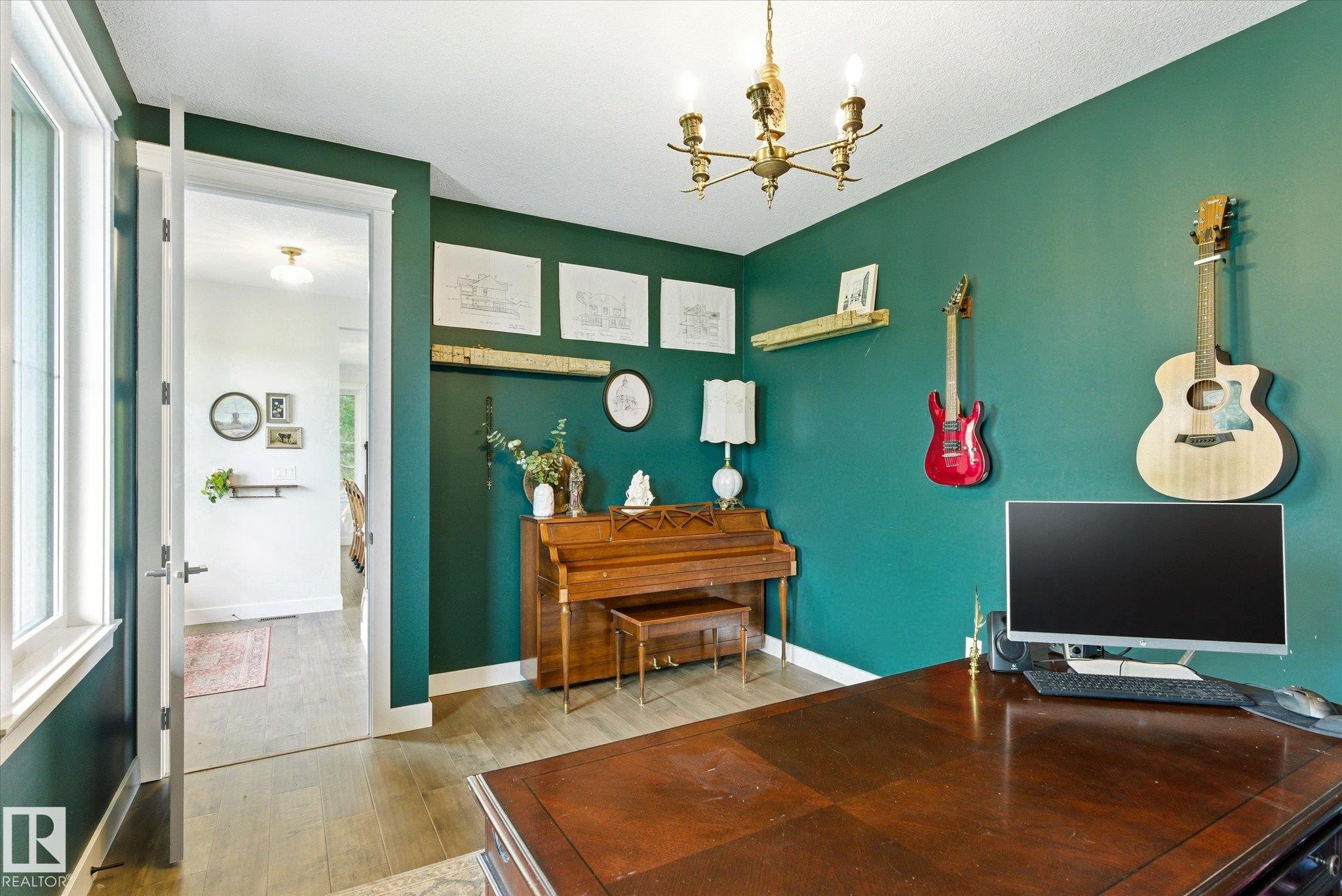 Room featuring dark green walls, wood-finish flooring, a brass chandelier, and white trim - 59102 Rge Road 234, Rural Westlock County, AB
