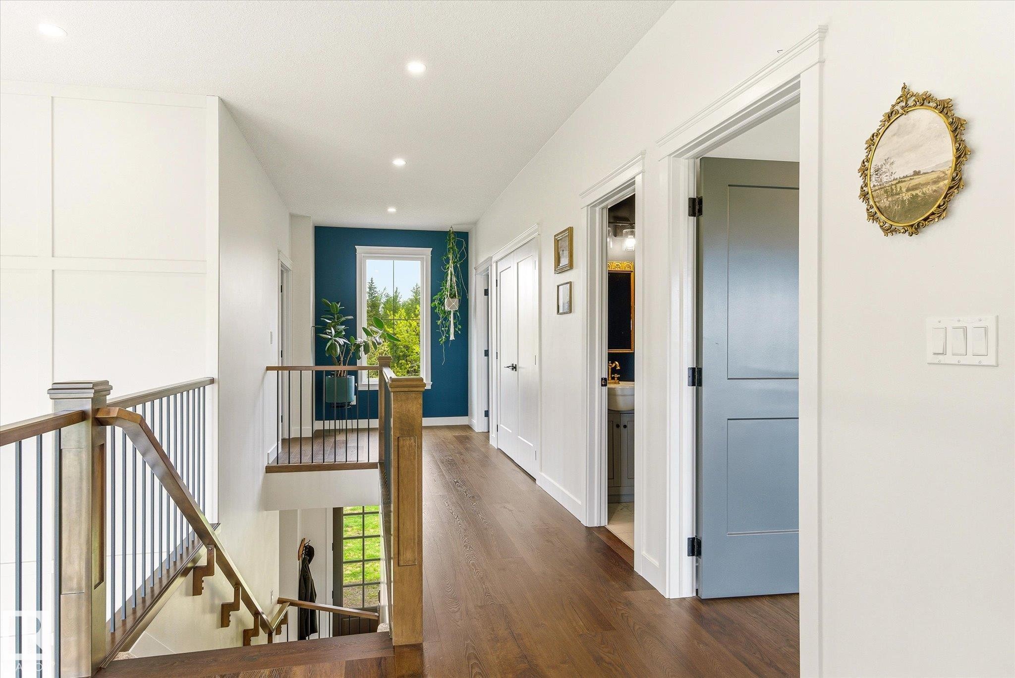 Hallway featuring wood-finish flooring, recessed lighting, white trim, and a prominent window with a bold accent wall - 59102 Rge Road 234, Rural Westlock County, AB