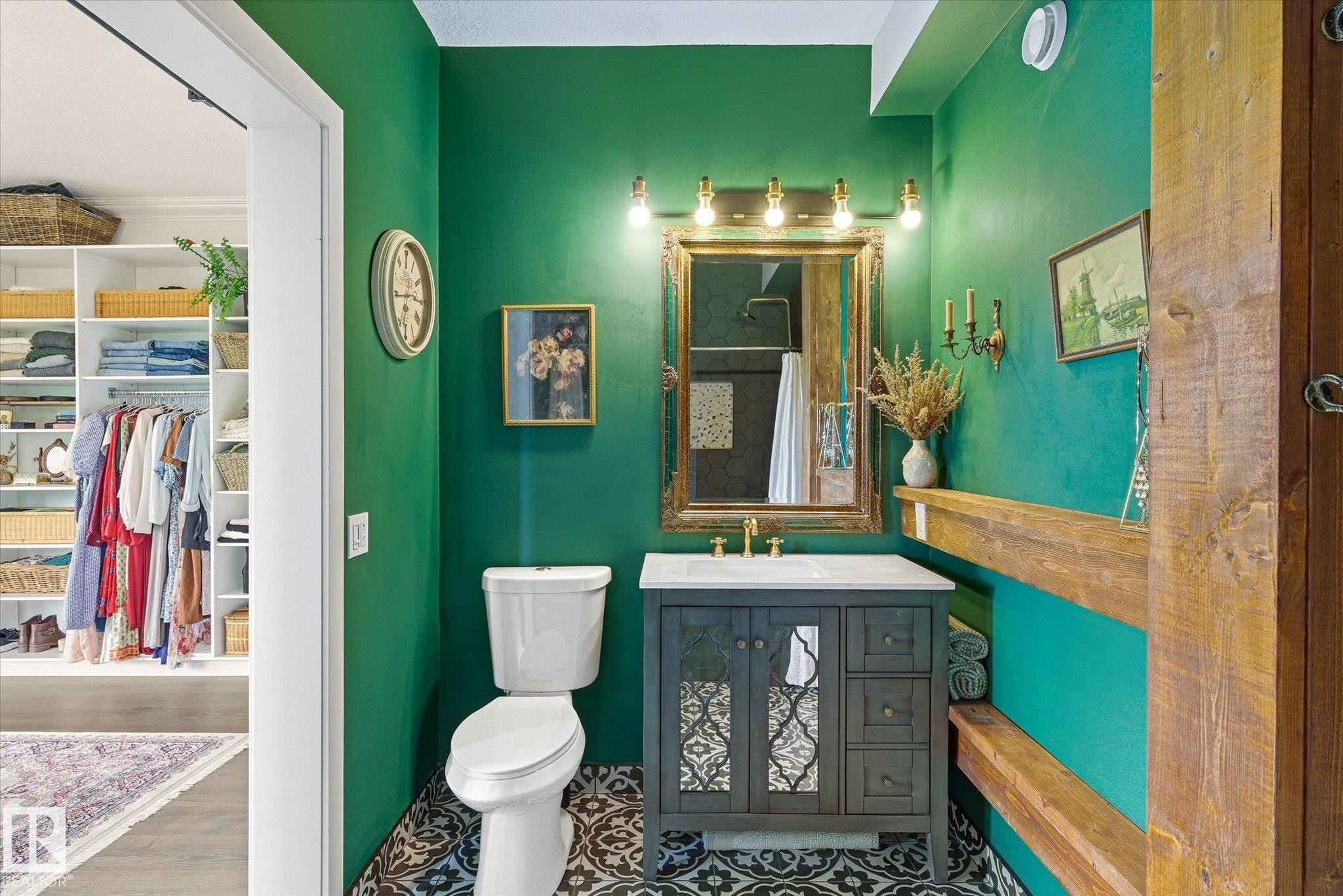Bathroom featuring a dark green accent wall, patterned floor tiles, a vanity with a white countertop, and an ornate mirror with brass-finish lighting - 59102 Rge Road 234, Rural Westlock County, AB
