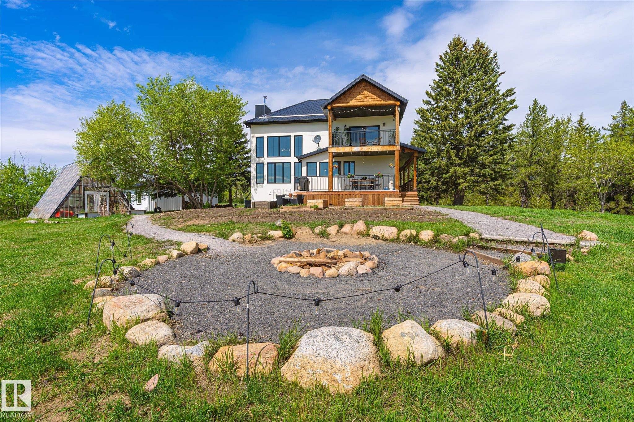 Outdoor fire pit area with gravel groundcover and natural stone surround - 59102 Rge Road 234, Rural Westlock County, AB