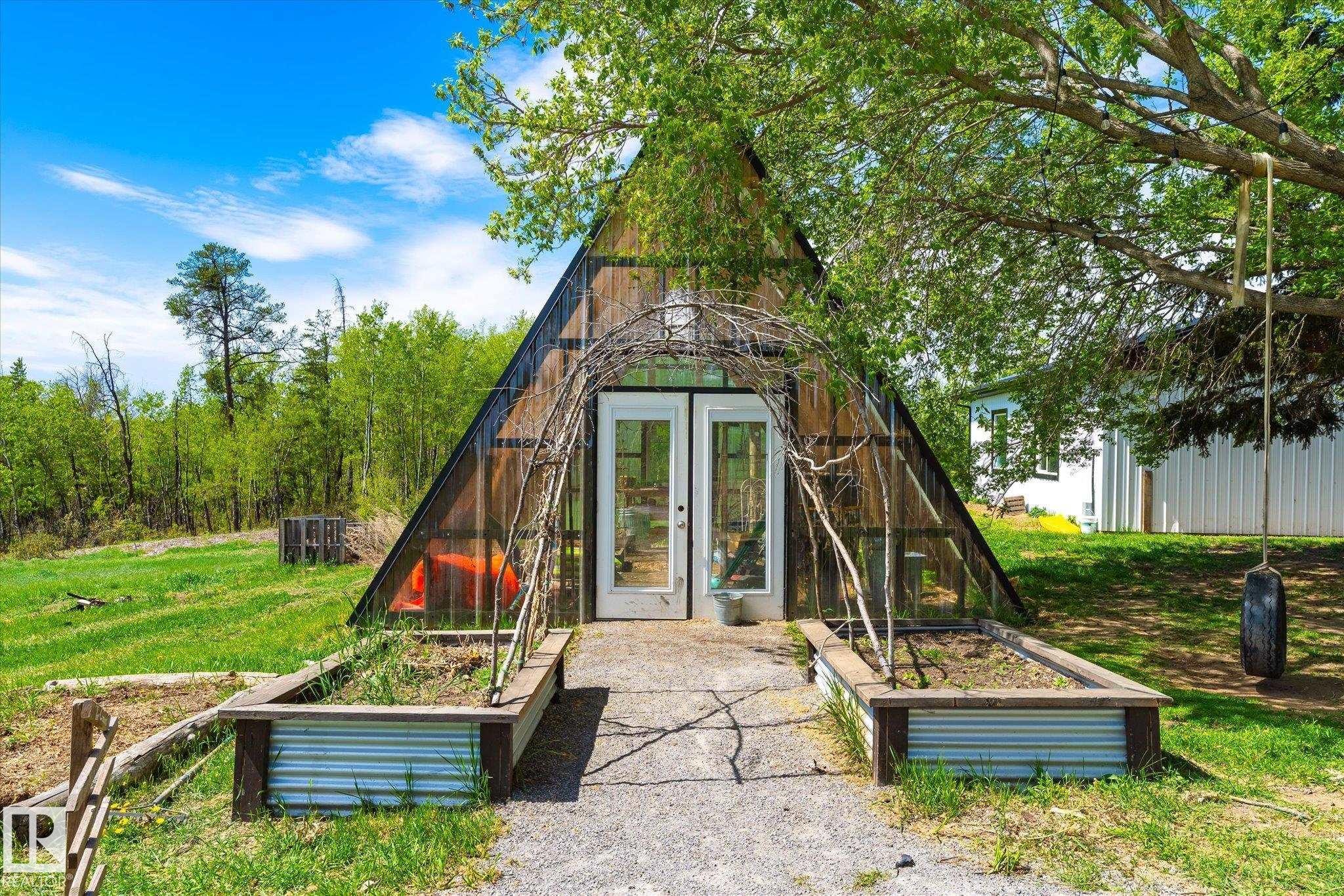 A-frame structure featuring a glass facade and double white entry doors - 59102 Rge Road 234, Rural Westlock County, AB